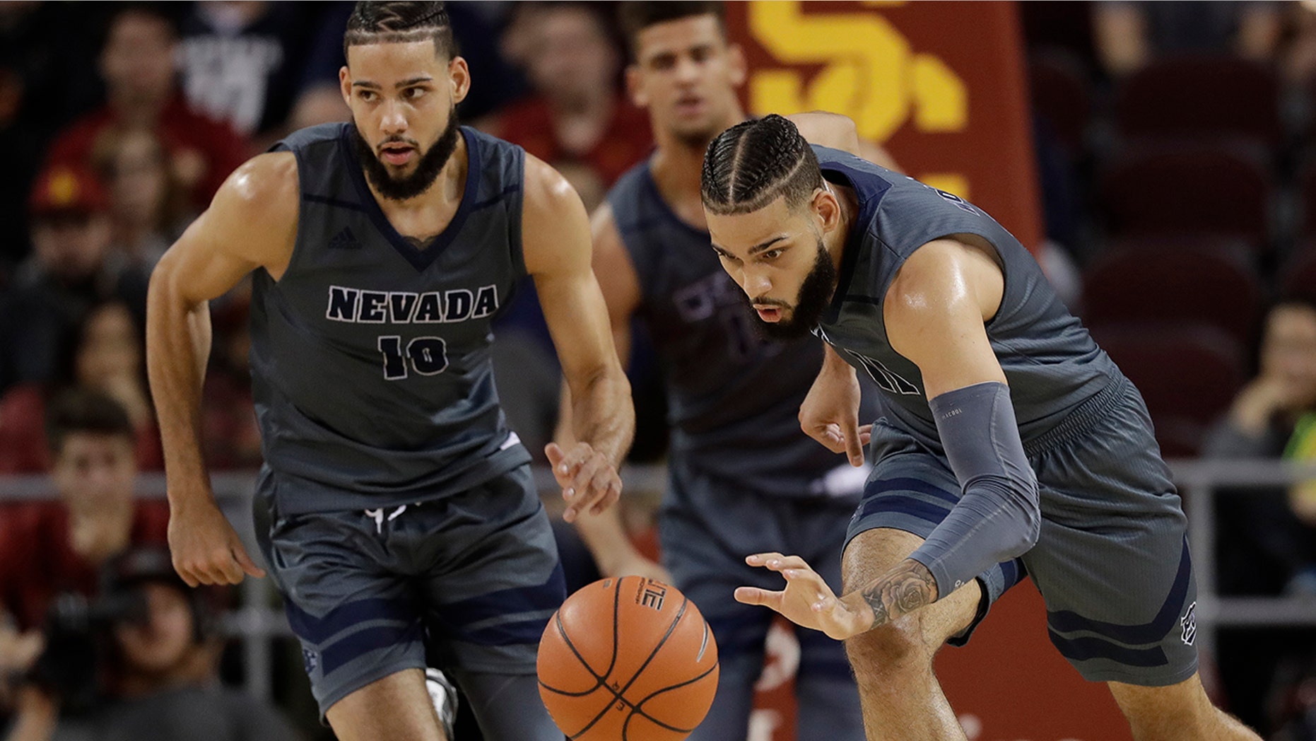 FILE - In this Dec. 1, 2018, file photo, Nevada forward Cody Martin, right, dribbles downcourt as his twin brother Caleb Martin, left, trails during the second half of an NCAA college basketball game against Southern California in Los Angeles.