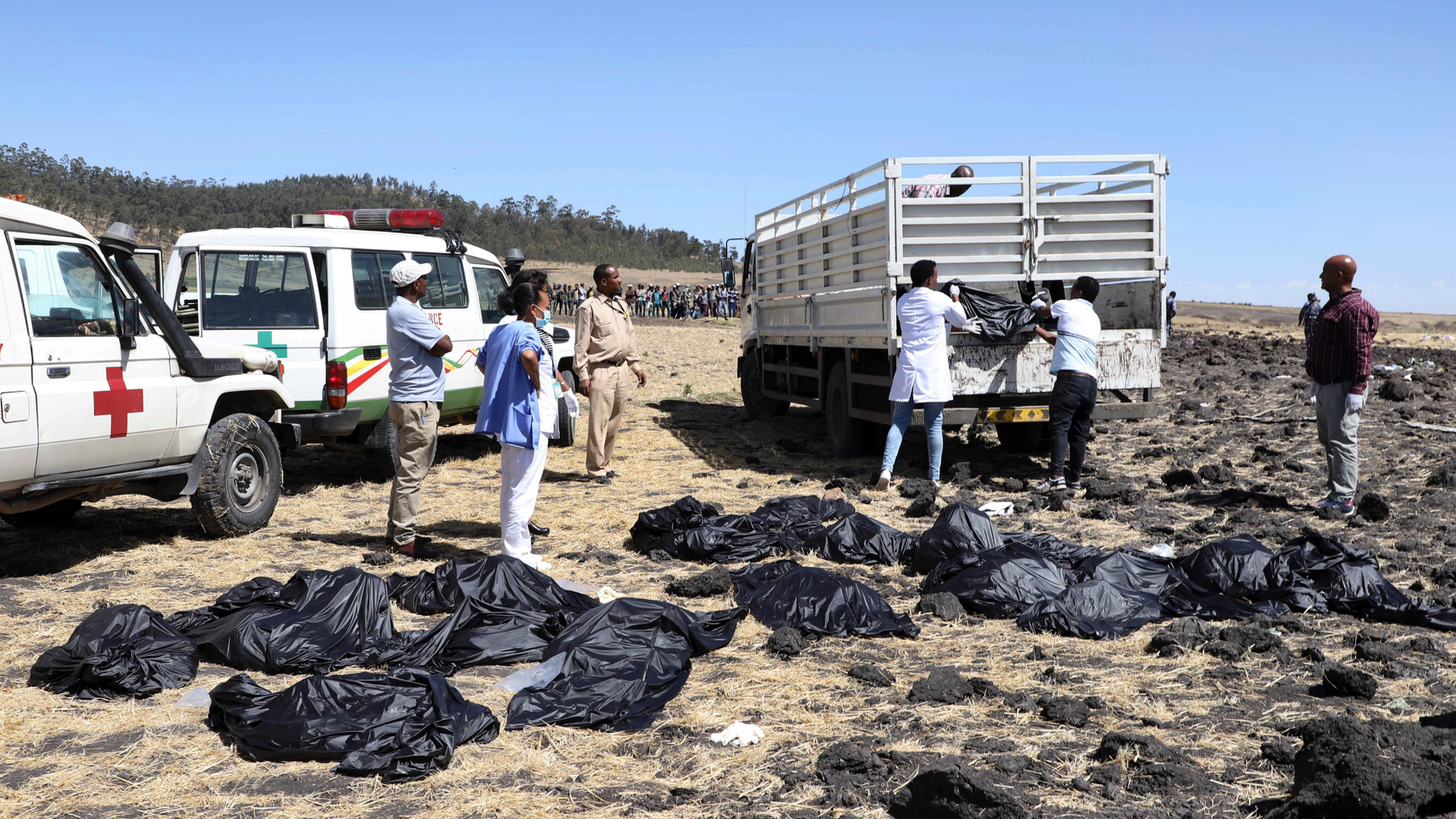 Rescuers remove body bags from the scene of an Ethiopian Airlines flight that crashed shortly after takeoff at Hejere near Bishoftu, or Debre Zeit, south of Addis Ababa, in Ethiopia Sunday. (AP Photo)