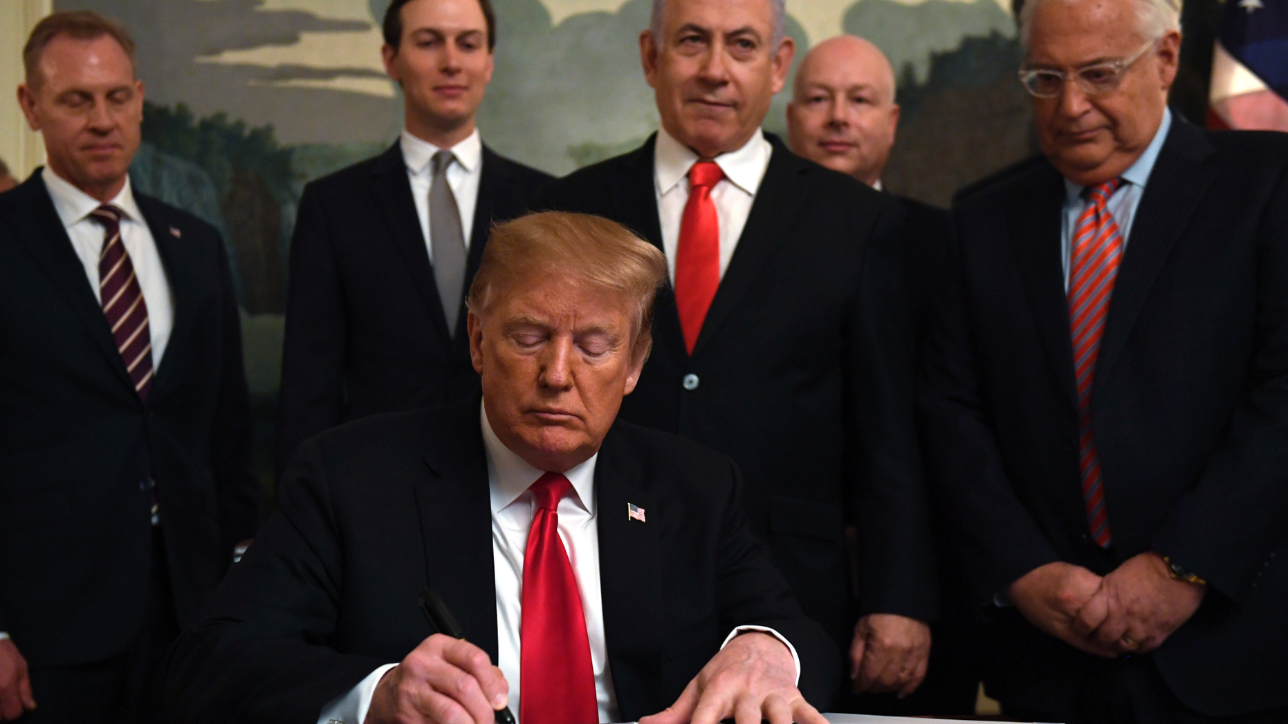 President Donald Trump, front, signs a proclamation in the Diplomatic Reception Room at the White House in Washington, Monday, March 25, 2019. Trump signed an official proclamation formally recognizing Israel's sovereignty over the Golan Heights. Others attending are, from left, Acting Defense Secretary Patrick Shanahan, White House adviser Jared Kushner, Israeli Prime Minister Benjamin Netanyahu, U.S. special envoy Jason Greenblatt, and U.S. Ambassador to Israel David Friedman. (AP Photo/Susan Walsh)