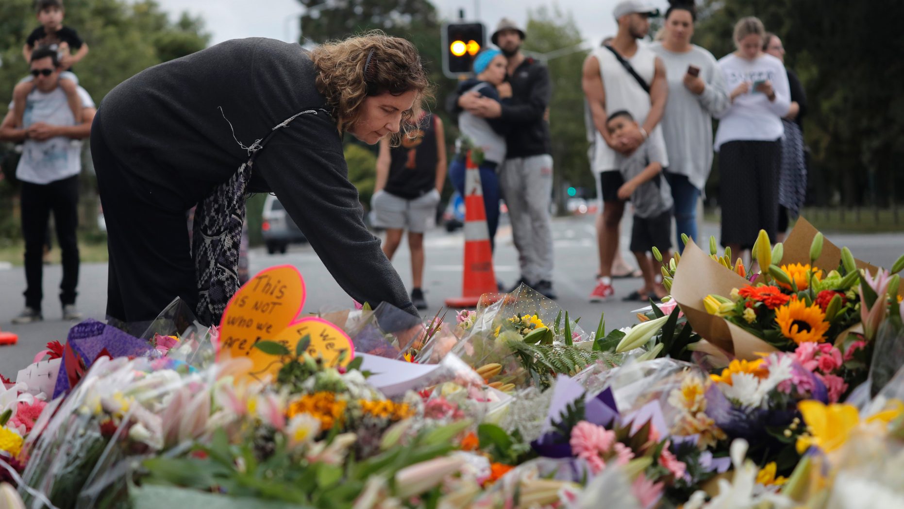 Mourners paying their respects at a makeshift memorial near the Masjid Al Noor mosque, Saturday, March 16, 2019, Christchurch, New Zealand, where one of the two mass shootings occurred. The white supremacist gunman appeared in court Saturday charged with murder in the mosque assaults that killed at least 49 people and led to the prime minister to call for a tightening of national gun laws. (AP Photo/Vincent Yu)