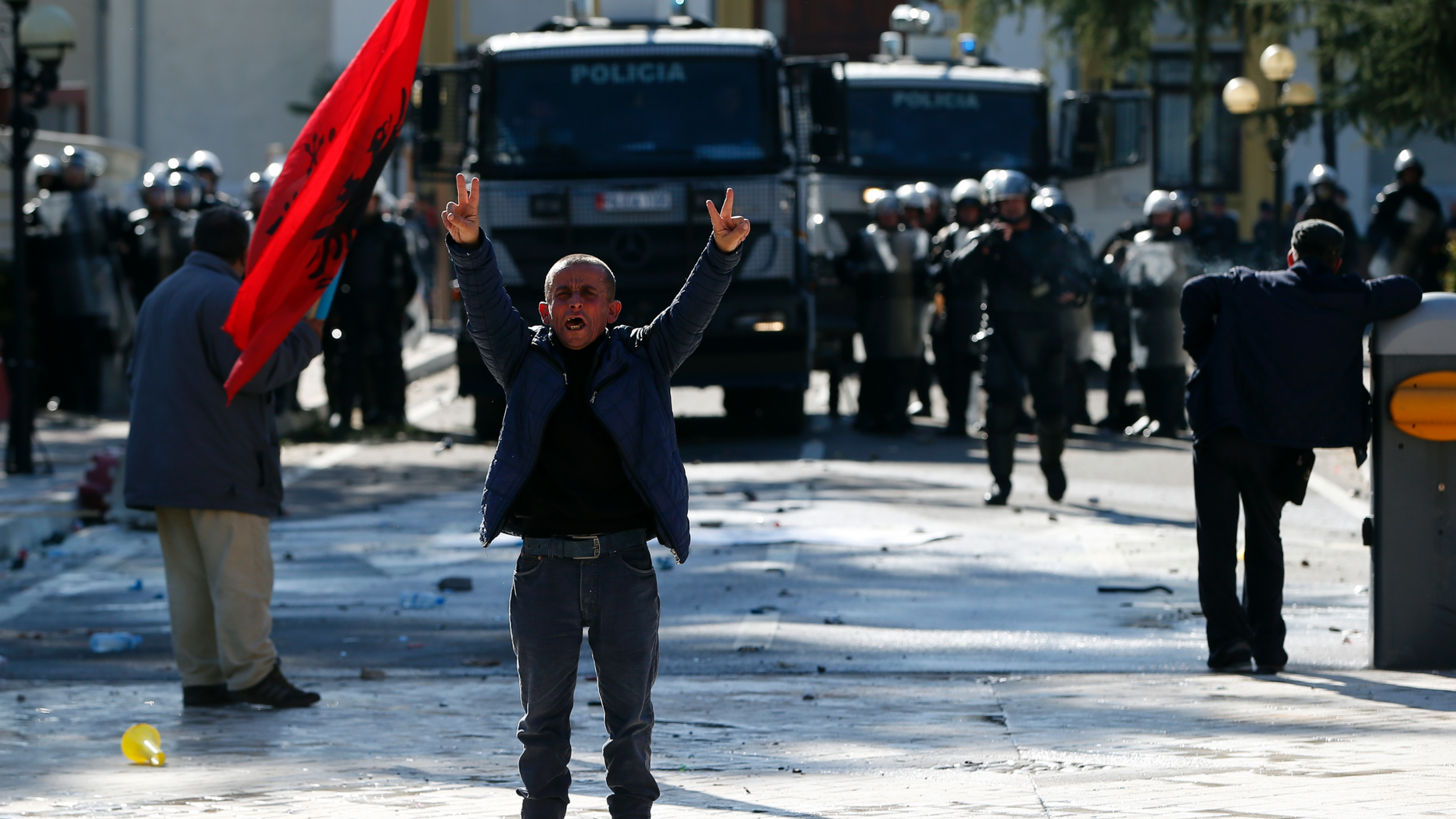 A protester flashes the victory sign as thousands of opposition supporters protest in Tirana, Albania on Saturday, March 16, 2019. Albanian opposition supporters clashed with police while trying to storm the parliament building Saturday in a protest against the government which they accuse of being corrupt and linked to organized crime.(AP Photo/Visar Kryeziu)