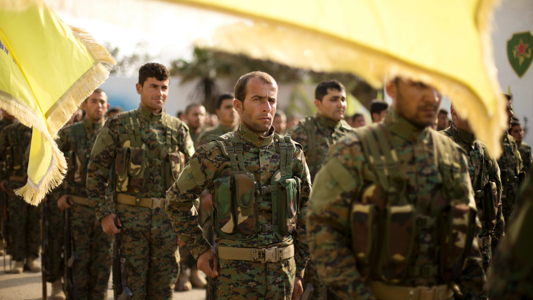 U.S.-backed Syrian Democratic Forces (SDF) stand in formation at a ceremony to mark their defeat of Islamic State militants in Baghouz, at al-Omar Oil Field base, Syria, Saturday, March 23, 2019. (AP Photo/Maya Alleruzzo)