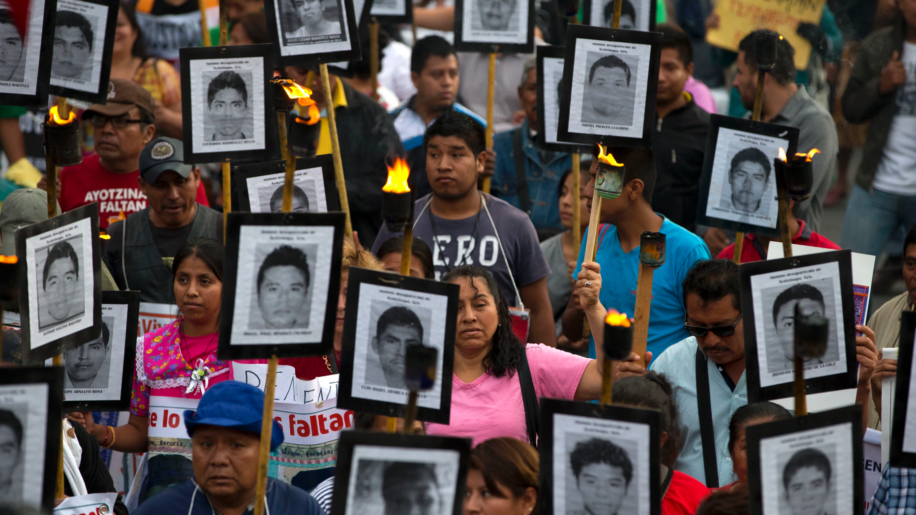 FILE - In this April 26, 2016 file photo, family members and supporters of 43 missing teachers college students carry pictures of the students as they march to demand the case not be closed and that experts' recommendations about new leads be followed, in Mexico City. On Sunday, March 24, 2019, Mexico’s President Andres Manuel Lopez Obrador vowed to ramp up efforts to identify thousands of bodies in government custody at forensic institutions across Mexico, while thousands more Mexicans are missing, their bodies presumed to be in clandestine graves. (AP Photo/Rebecca Blackwell, File)