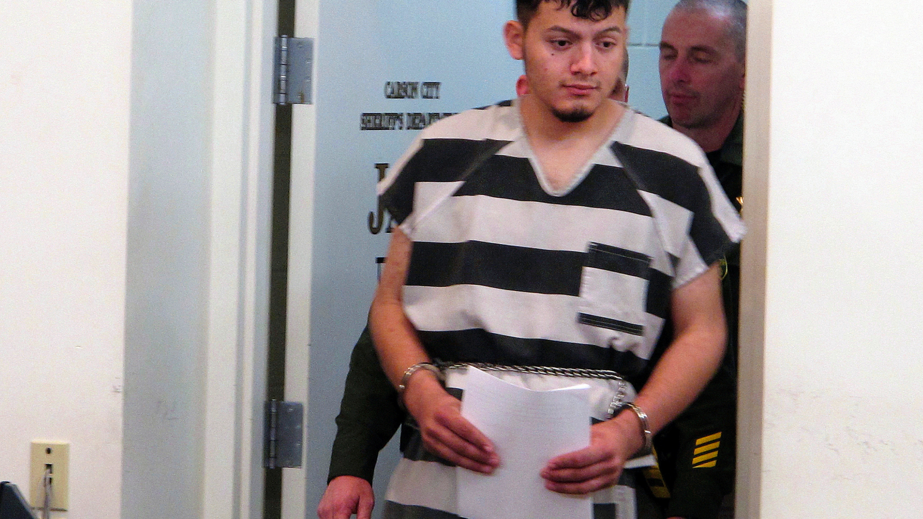 FILE - In this Jan. 24, 2019 file photo, Wilber Ernesto Martinez-Guzman, 19, of El Salvador, is escorted into the courtroom for his initial appearance in Carson City Justice Court in Carson City, Nev. A detective says the Salvadoran immigrant charged with four Nevada murders told police he robbed and killed his elderly victims during a 10-day rampage in January because he needed money to buy methamphetamine. According to a grand jury transcript obtained by The Associated Press, the Reno detective testified last week that Martinez-Guzman broke into tears and repeatedly called himself an "idiot" before confessing to the murders. (AP Photo/Scott Sonner, File)