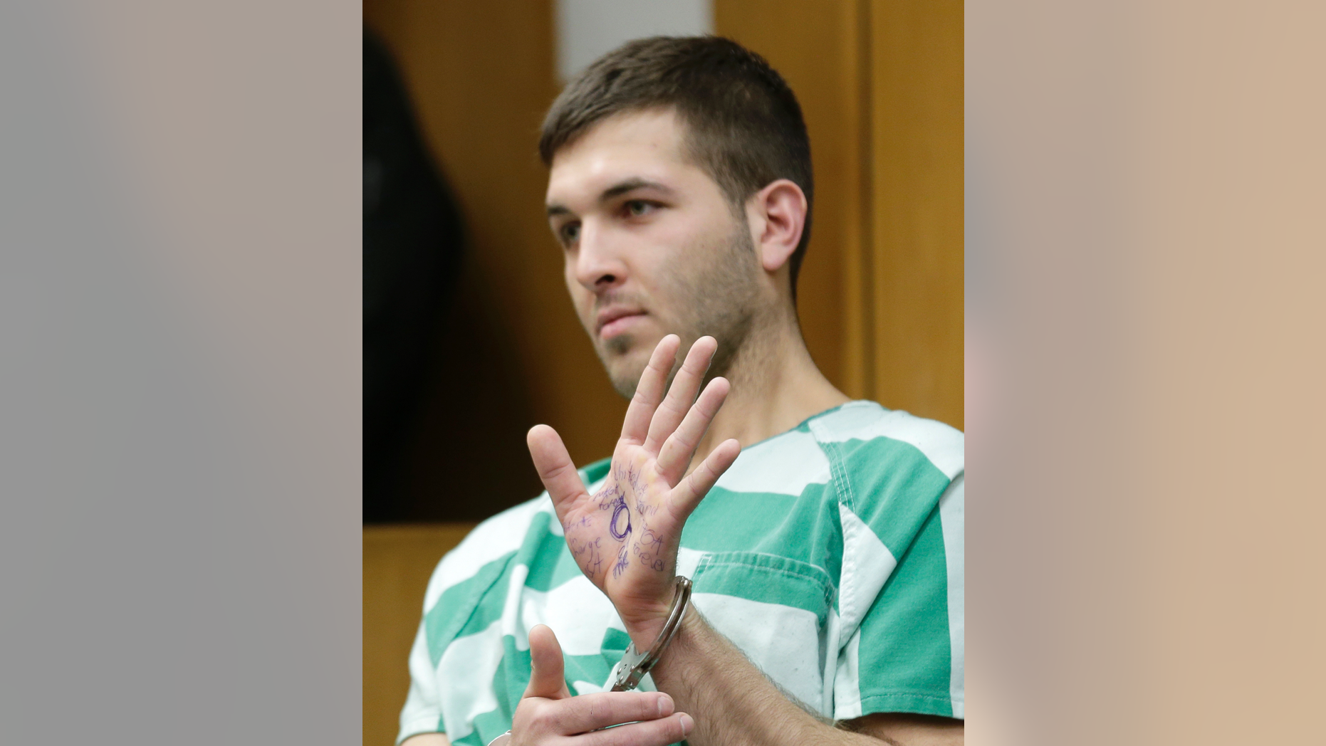 Anthony Comello displays writing on his hand during his extradition hearing in Toms River, N.J., Monday, March 18, 2019. New York City police say a suspect is in custody in the shooting death of the reputed Gambino crime family boss. Chief of Detectives Dermot Shea says 24-year-old Comello was arrested Saturday, March 16, 2019, in the death of Francesco Cali on Wednesday in front of his Staten Island home. (AP Photo/Seth Wenig)