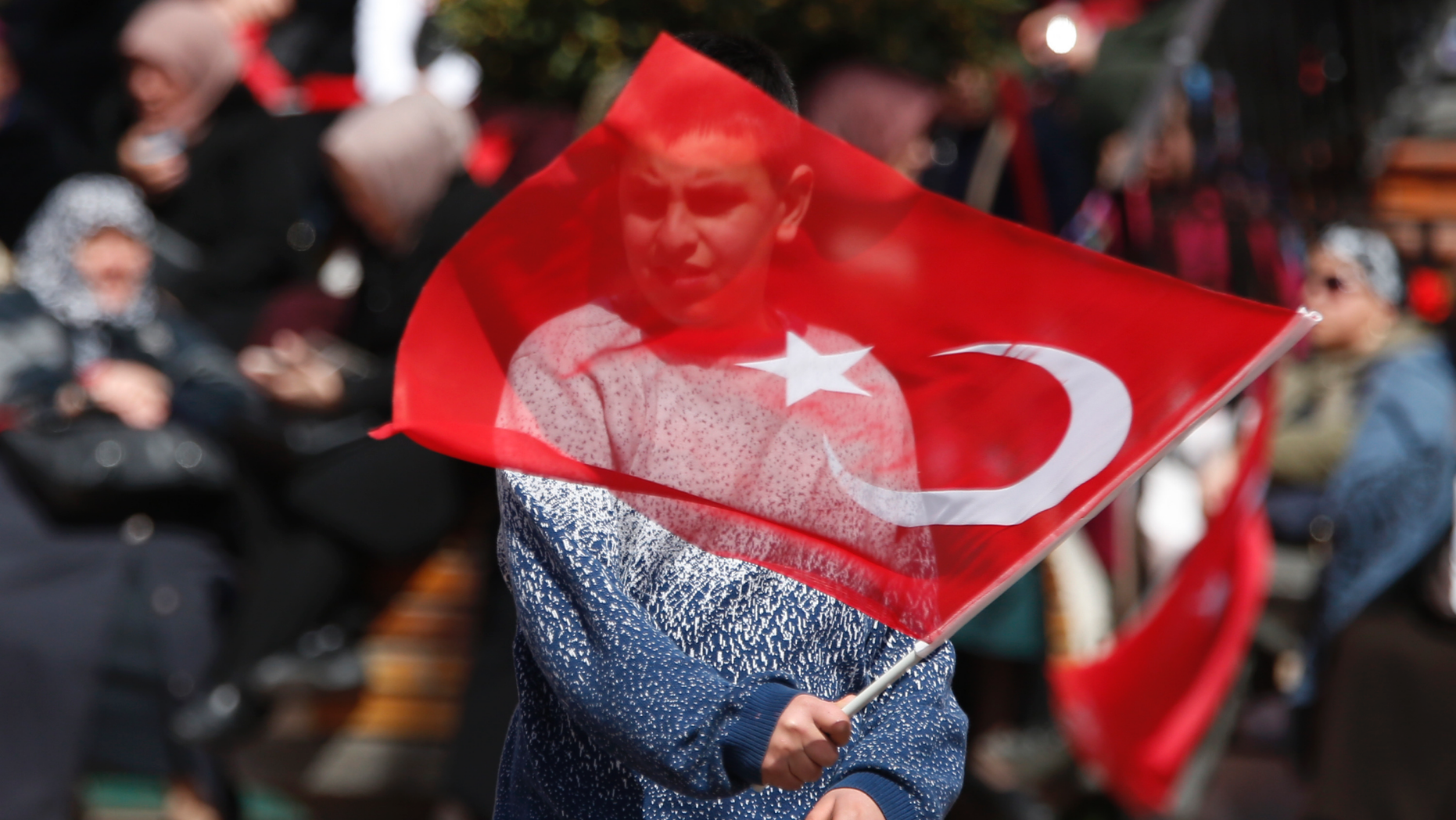 A supporter of Turkey's President Recep Tayyip Erdogan waves a flag at a rally of his ruling Justice and Development Party's (AKP), in Istanbul, Friday, March 29, 2019, ahead of local elections scheduled for March 31, 2019. (AP Photo/Lefteris Pitarakis)