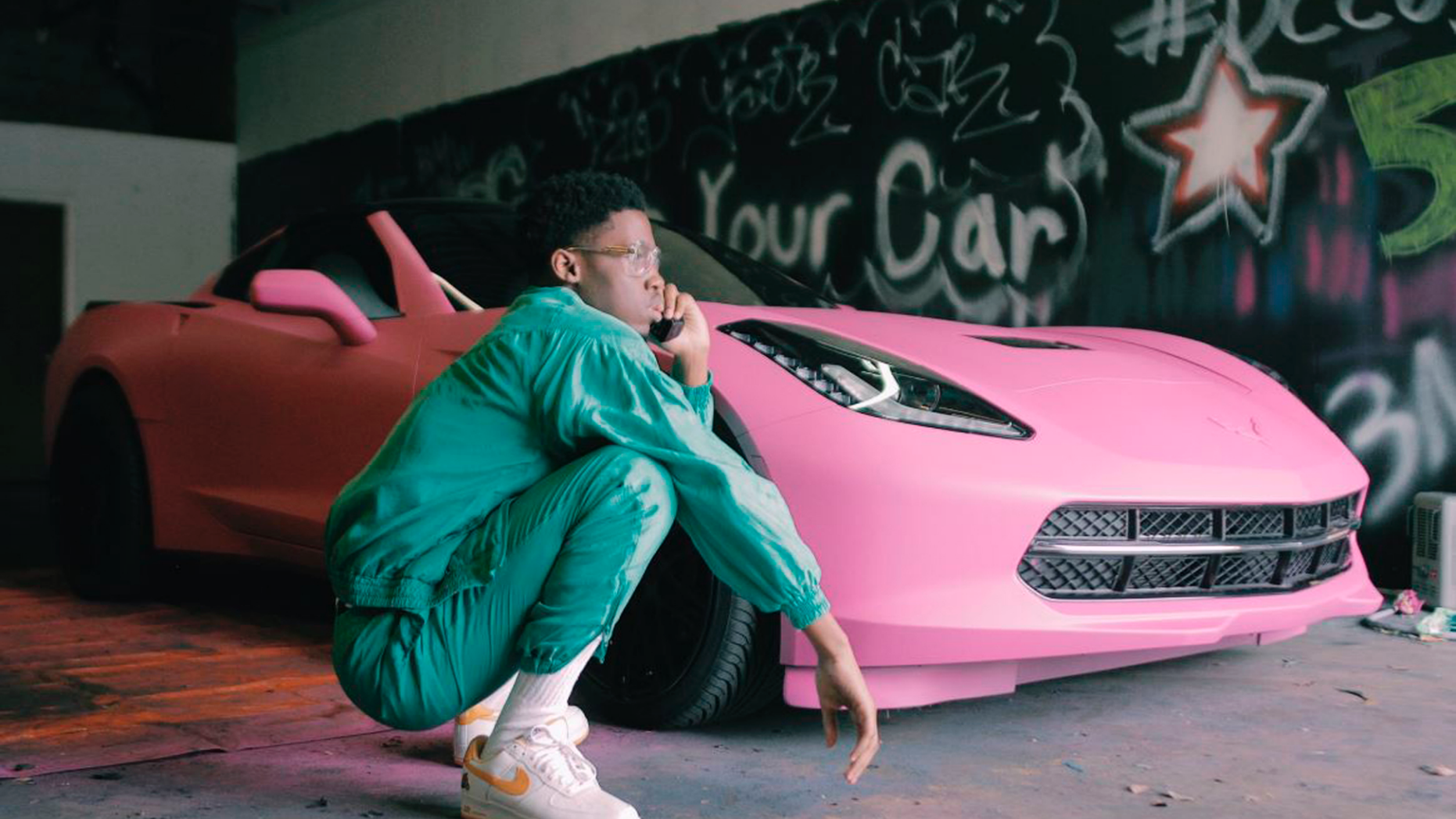 This January 2017 photo provided by Shawn Cotton shows Cotton posing by his $55,000 pink Corvette, purchased with profits he made as a videographer in a new and uniquely dangerous field of news in which reporters go into high-crime areas to interview street-gang members and rappers. (Dance Dailey/Courtesy of Shawn Cotton via AP)