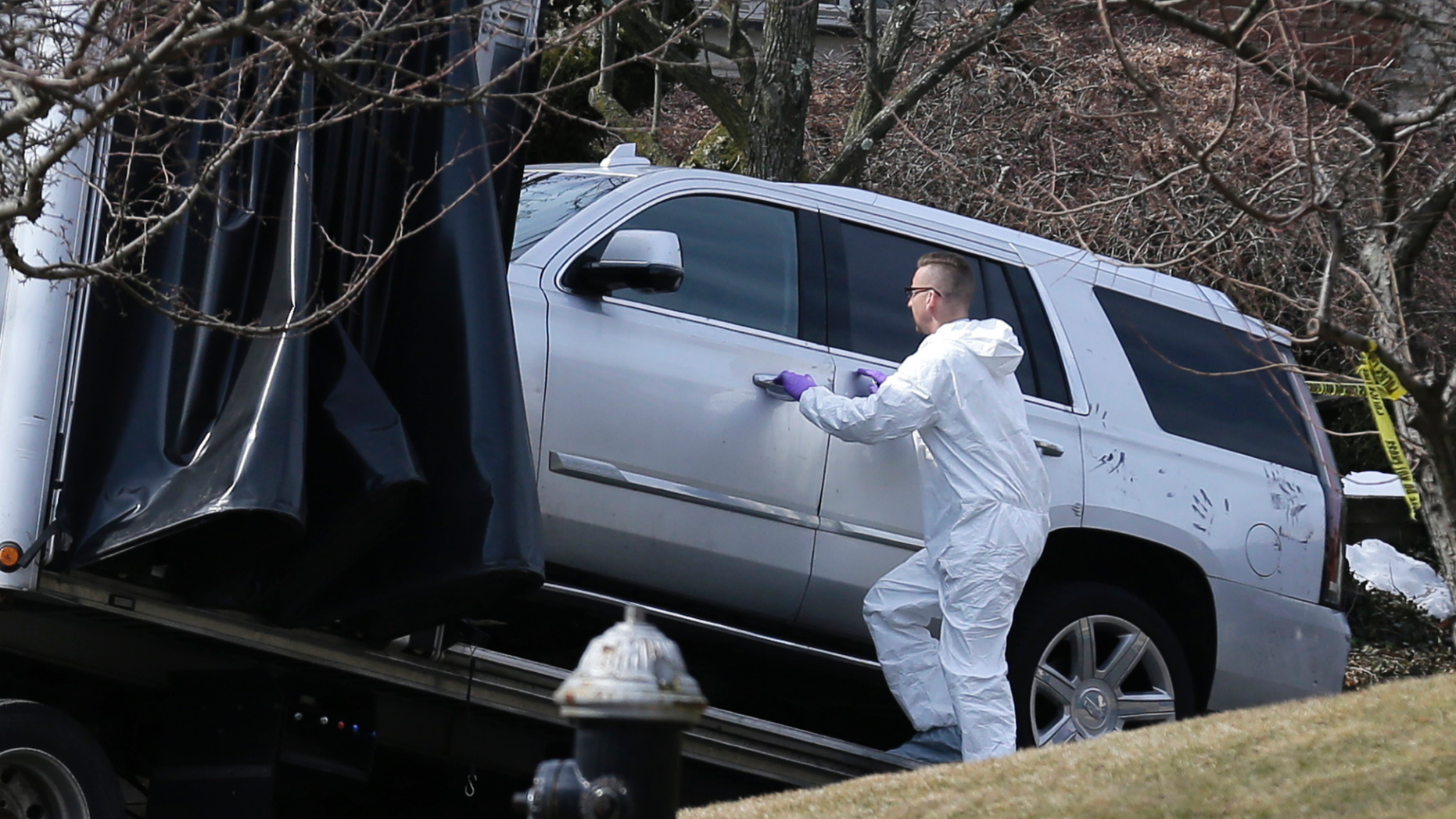 Crime scene investigators load a car that appears to have been checked for fingerprints onto a flatbed truck in the Staten Island borough of New York, Thursday, March 14, 2019. Francesco "Franky Boy" Cali was found with multiple gunshot wounds at his red-brick colonial-style house on Staten Island on Wednesday night and was pronounced dead at a hospital. (AP Photo/Seth Wenig)