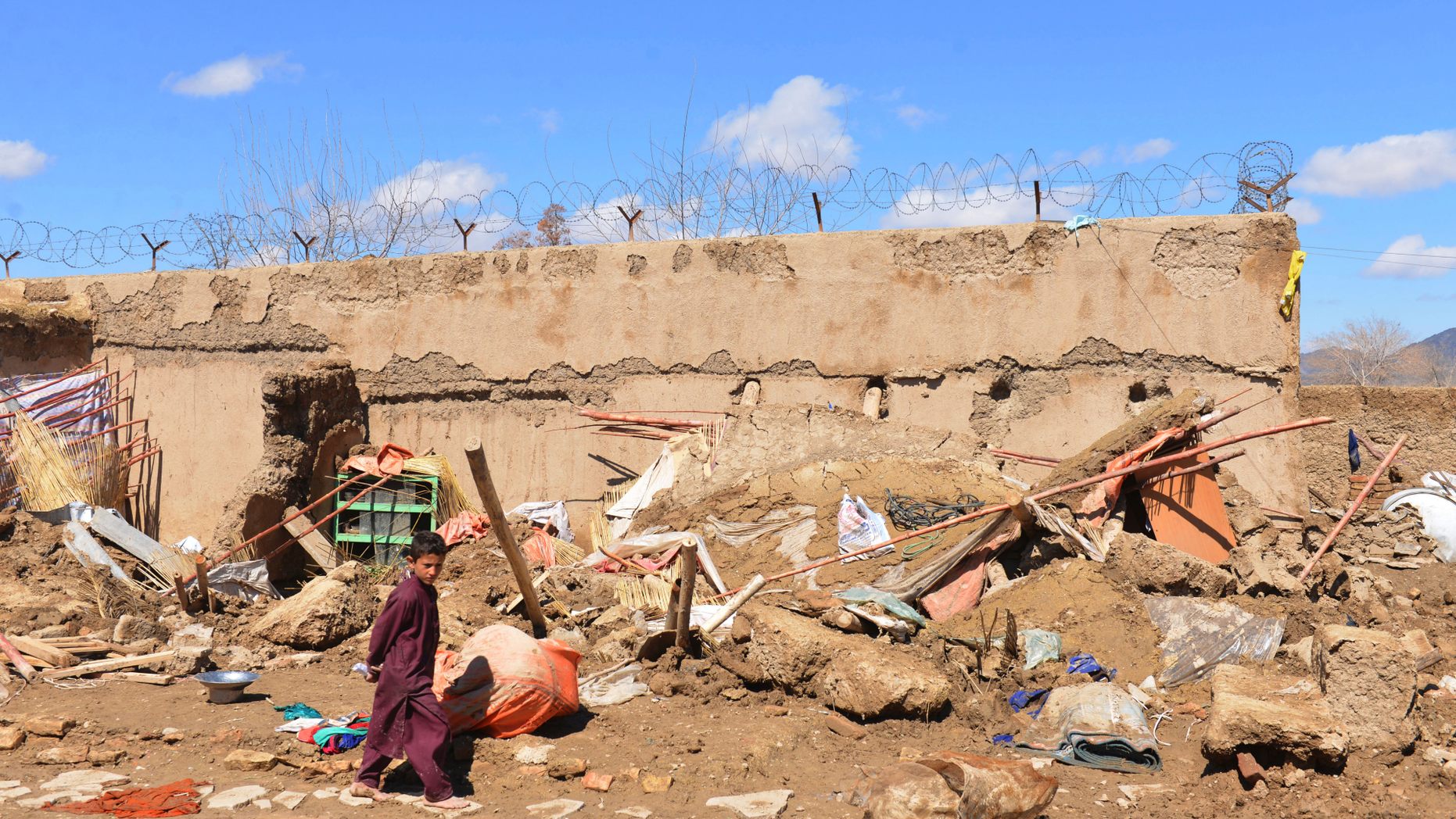 A boy walks inside what is left of a home that was damaged by heavy rains in Kandahar province, south of Kabul, Afghanistan, Sunday, March, 3, 2019. The U.N. Office for the Coordination of Humanitarian Affairs said at least 20 people have died as heavy rains and flooding over the past few days swept away their homes and cars in southern Afghanistan's Kandahar province. The U.N. humanitarian agency said on Saturday night that at least 10 people, including children, remain missing. (AP Photo/Sidiqullah Khan)