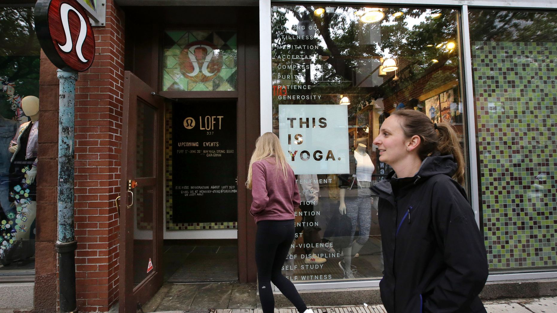 FILE- In this June 5, 2017, file photo, people walk near an entrance to a Lululemon Athletica store on Newbury Street in Boston. Lululemon Athletica Inc. reports earnings on Wednesday, March 27, 2019. (AP Photo/Steven Senne, File)