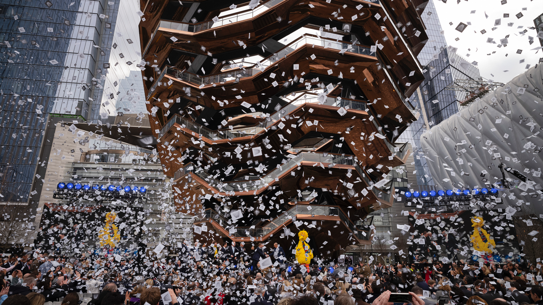 Confetti swirls around "Vessel" on its opening day at Hudson Yards, Friday, March 15, 2019, in New York. Hudson Yards, a $25 billion urban complex on Manhattan's west side, is the city's most ambitious development since the rebuilding of the World Trade Center. When fully complete, the 28-acre site will include 16 towers of homes and offices, a hotel, a school, the highest outdoor observation deck in the Western Hemisphere, a performing arts center, Vessel and a shopping mall. (AP Photo/Mark Lennihan)
