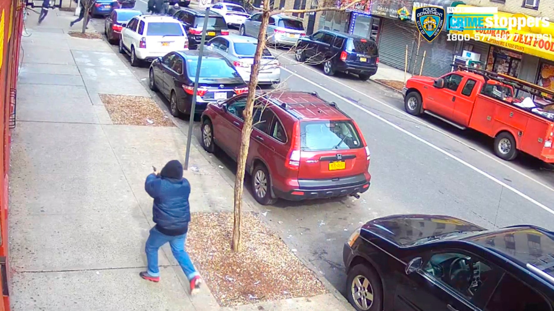In this Feb. 22, 2019 image taken from surveillance video released by the New York City Police Department, a gunman identified by the NYPD as 16-year-old Edgar Garcia opens fire on a crowded street in the Bronx borough of New York. No one was hit by the gunfire. (New York City Police Department via AP)