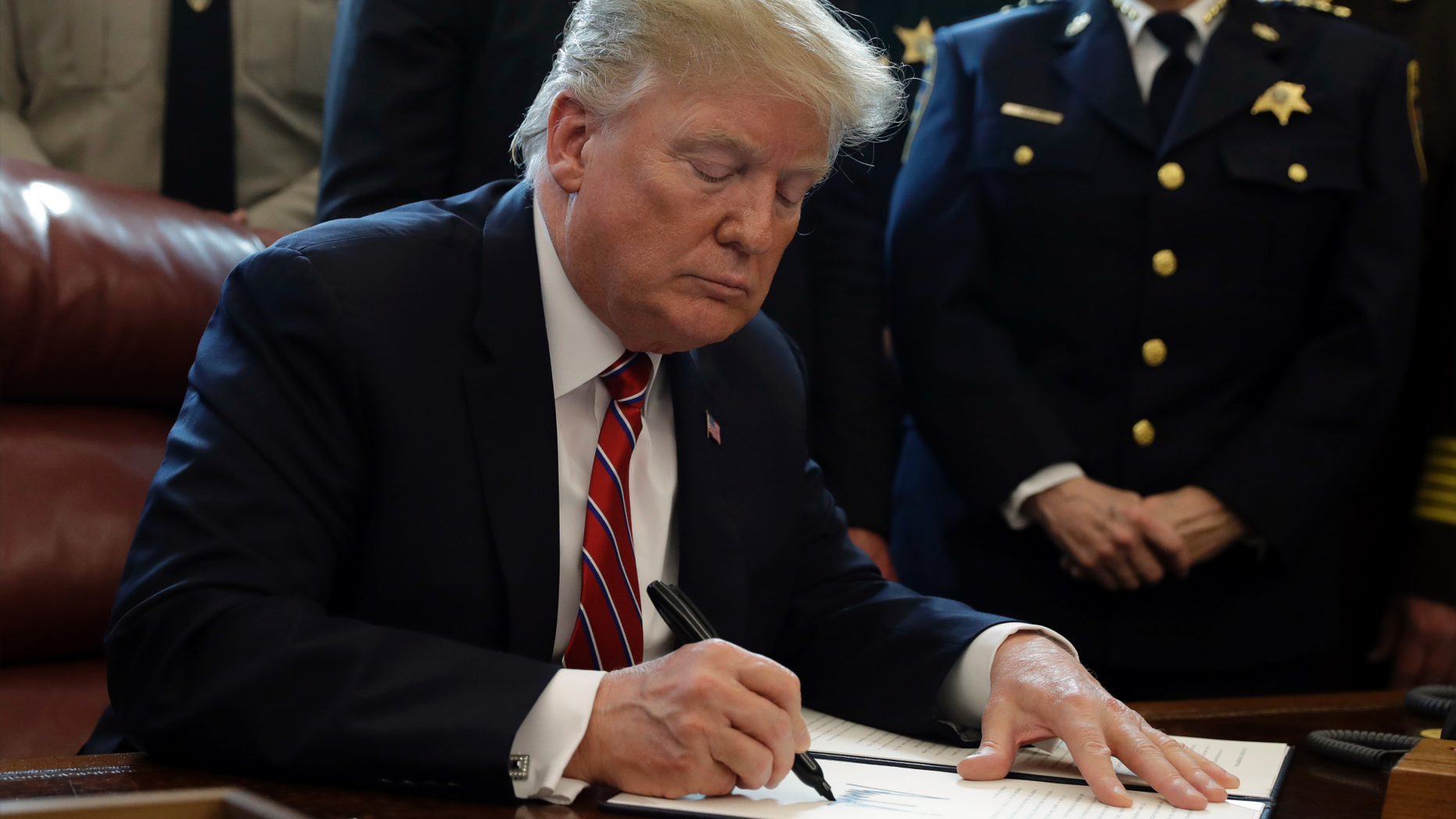 President Donald Trump signs the first veto of his presidency in the Oval Office of the White House, Friday, March 15, 2019, in Washington. Trump issued the first veto, overruling Congress to protect his emergency declaration for border wall funding. (AP Photo/Evan Vucci)