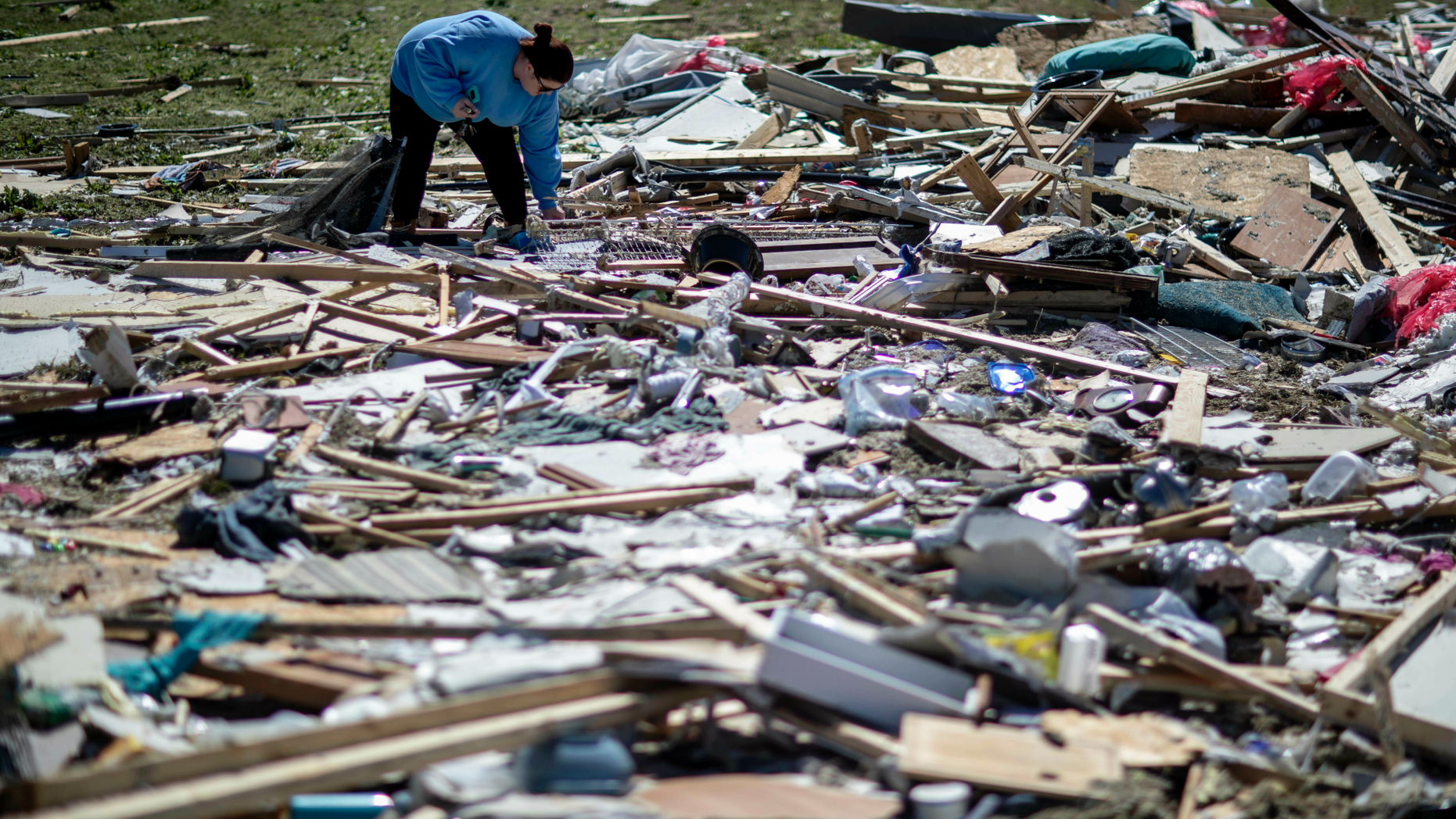 Kayla Causey sifts through the debris while helping her mother retrieve personal items after a tornado destroyed her home in Beauregard, Ala., Tuesday, March 5, 2019. (AP Photo/David Goldman)