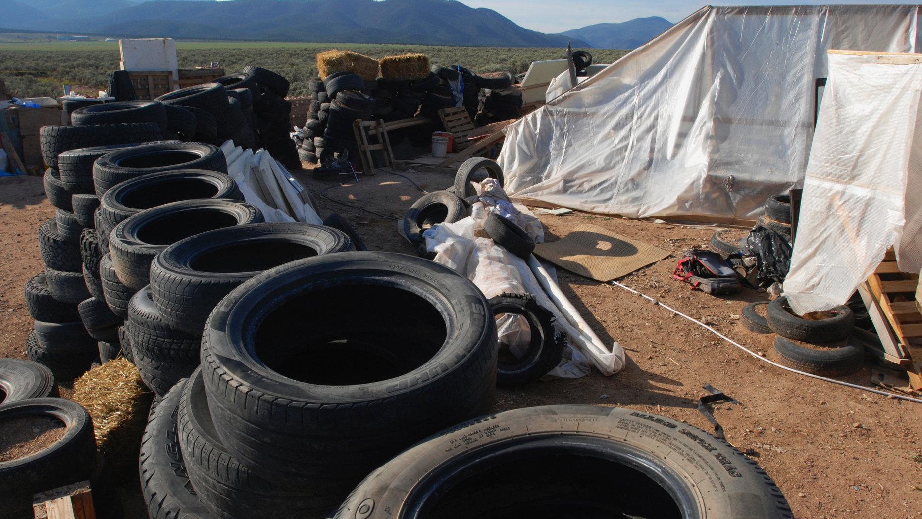 FILE - In this Aug. 10, 2018, file photo, is a makeshift living compound in Amalia, N.M. The five men and women found living in a ramshackle compound in northern New Mexico where a boy was found dead last year have been indicted on federal charges related to terrorism, kidnapping and firearms violations. The U.S. attorney's office in New Mexico announced the superseding indictment Thursday, March 14, 2019. (AP Photo/Morgan Lee, File)