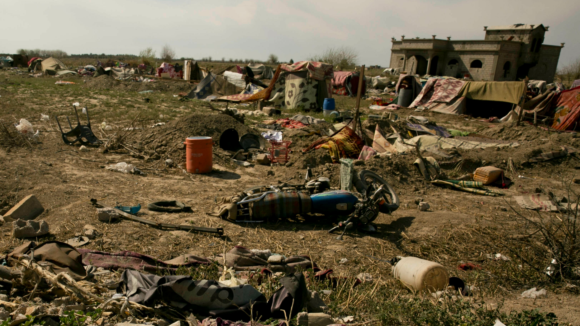 An Islamic State militant flag, foreground ,lies in a tent encampment after U.S.-backed Syrian Democratic Forces (SDF) fighters took control of Baghouz, Syriaon Saturday, March 23, 2019. The elimination of the last Islamic State stronghold in Baghouz brings to a close a grueling final battle that stretched across several weeks and saw thousands of people flee the territory and surrender in desperation, and hundreds killed. (AP Photo/Maya Alleruzzo)