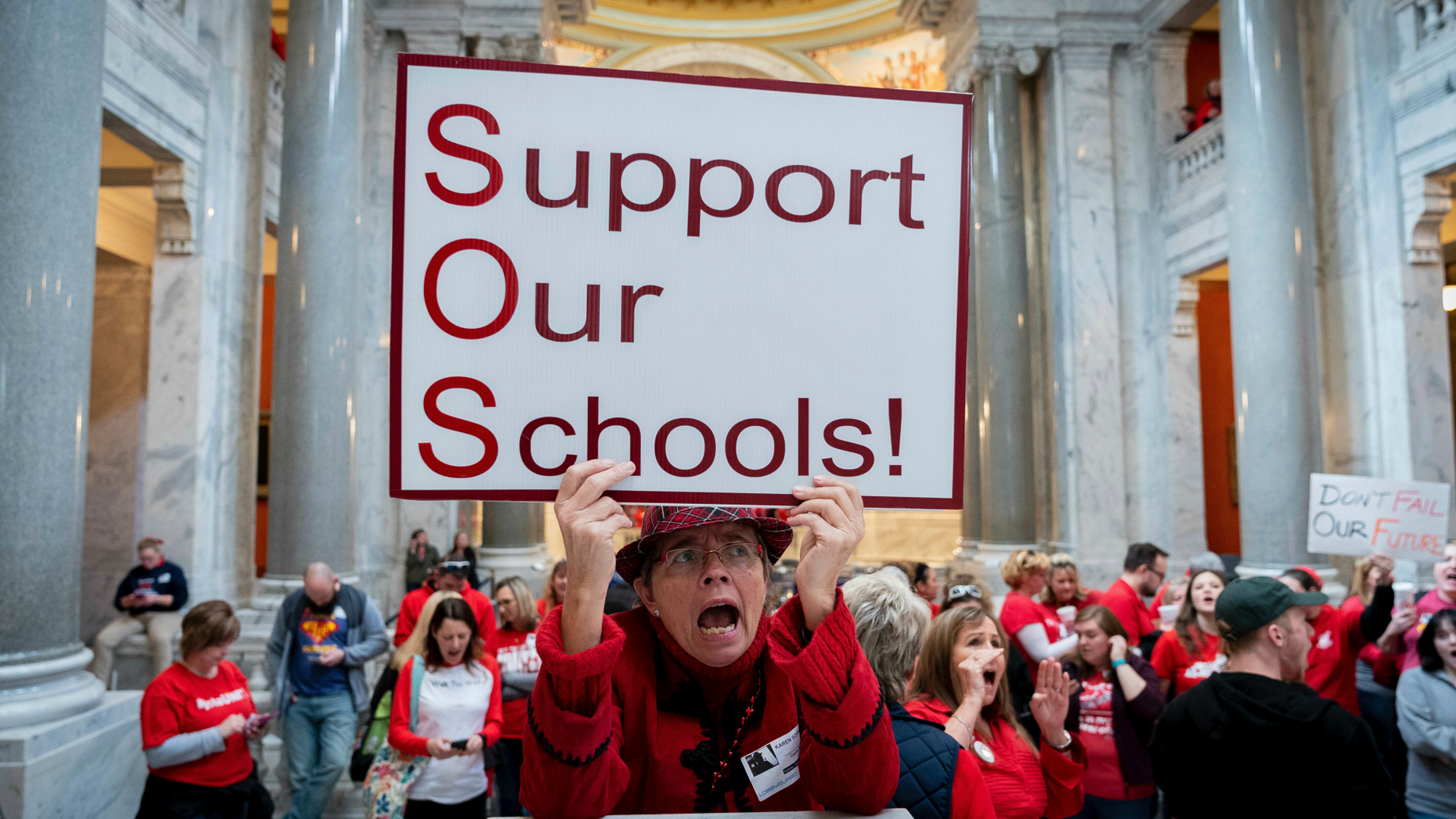 Karen Schwartz, a teacher at Phoenix School of Discovery in Louisville, stands with other teaches and their supporters to protest perceived attacks on public education, in Frankfort, Ky, Tuesday, March 12, 2019. (AP Photo/Bryan Woolston)