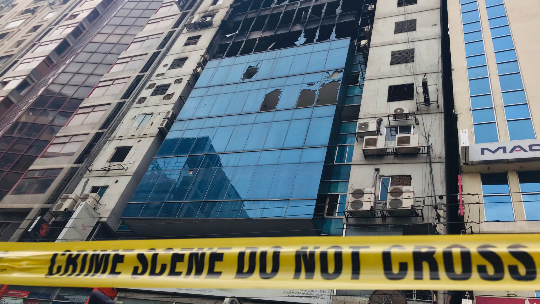 CORRECTS PHOTOGRAPHER'S NAME - A high-rise office building damaged by Thursday's fire is pictured in Dhaka, Bangladesh Friday, March 29, 2019. A Bangladeshi housing official said Friday criminal charges would be filed against the owner of the building where a fire killed dozens of people and which had four upper floors constructed illegally.(AP Photo/Al-emrun Garjon)