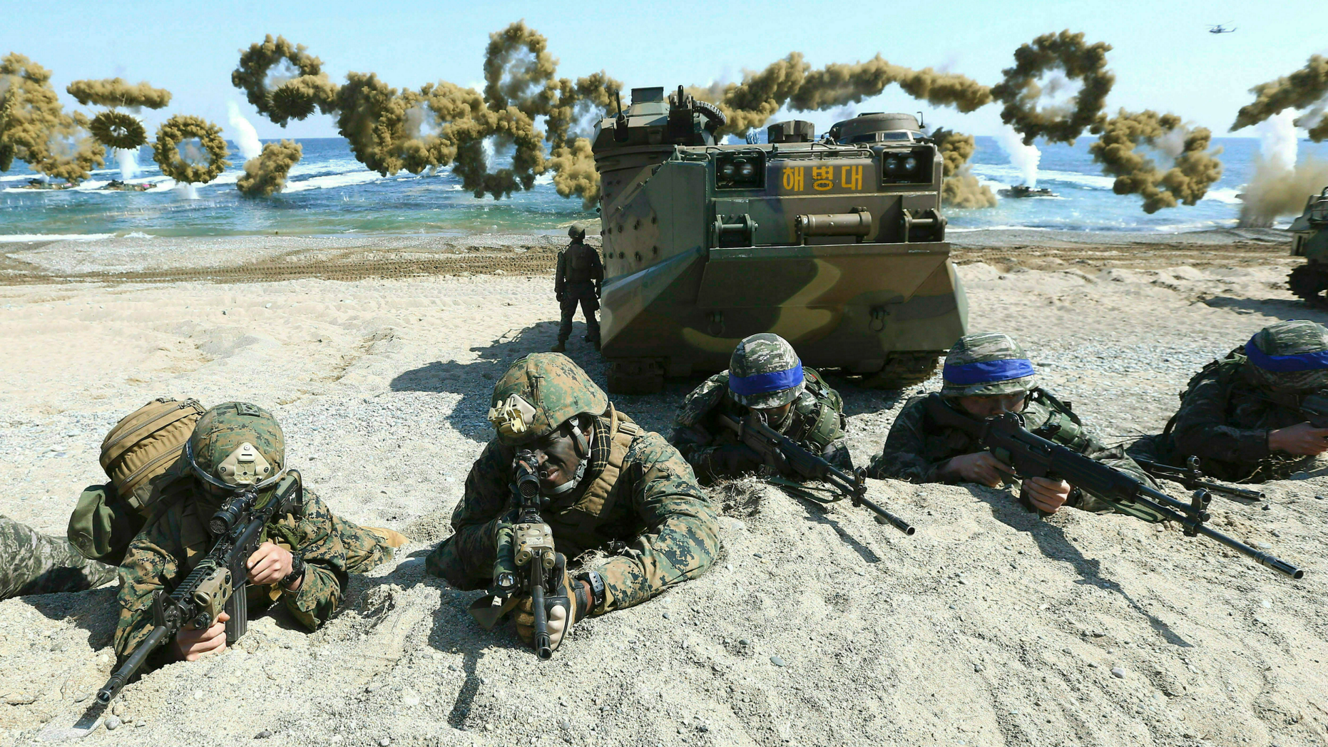 FILE - In this March 12, 2016, file photo, Marines of the U.S., left, and South Korea, wearing blue headbands on their helmets, take positions after landing on a beach during the joint military combined amphibious exercise, called Ssangyong, part of the Key Resolve and Foal Eagle military exercises, in Pohang, South Korea. South Korea and the U.S. say they've decided to end their springtime military drills to back diplomacy with North Korea. (Kim Jun-bum/Yonhap via AP, File)