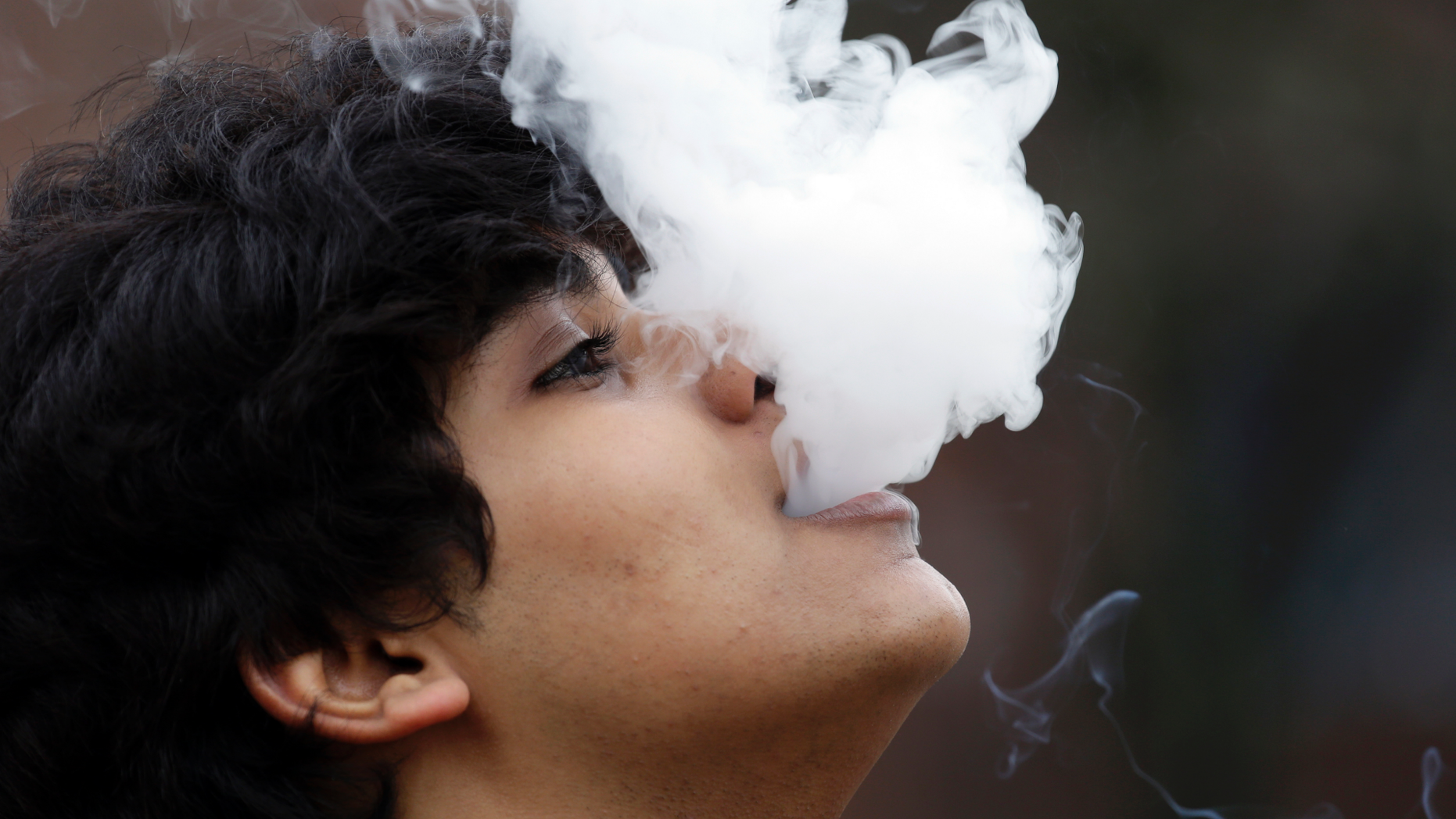 FILE - In this Jan. 7, 2016, file photo, a man who declined to be identified blows out a cloud of smoke as he puffs on a small pipe outside at Seattle Central College in Seattle. A proposal to raise Washington's smoking and vaping age to 21 has passed the Legislature on Wednesday, March 27, 2019, putting the state on the precipice of becoming the ninth state to make such a change. The Texas Senate approved a similar bill that would raise the legal age to buy and use tobacco products from 18 to 21, exempting active U.S. military members from the age raise.