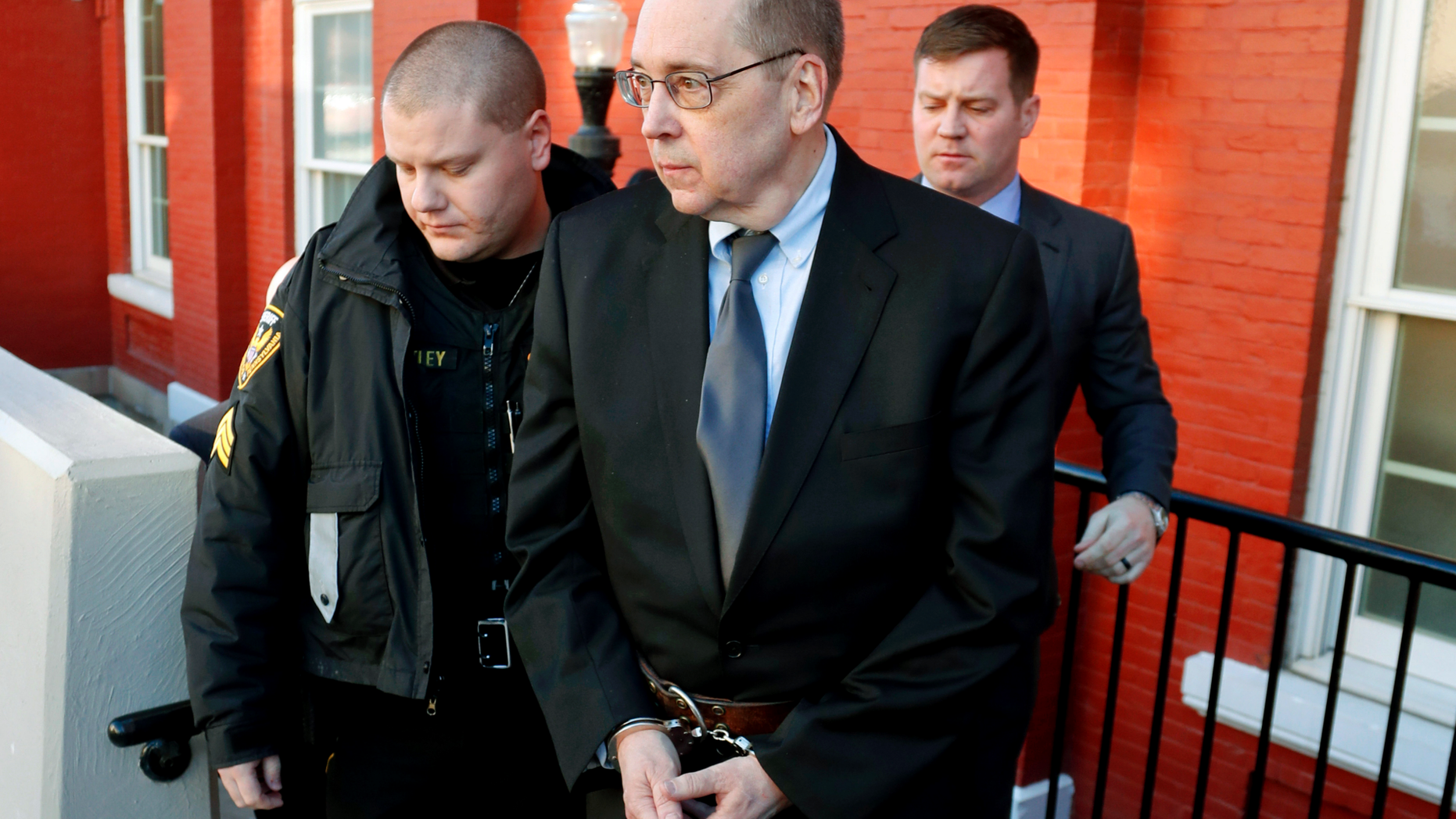 FILE - In this Jan. 11, 2019 file photo, David Poulson, center, a Roman Catholic priest who pleaded guilty to sexually abusing two boys, is taken away from court after sentencing in Brookville, Pa. It was announced Tuesday March 26 that the Diocese of Erie has agreed to pay $2 million to a man who was sexually abused as a child by Poulson, who made him say confession after the assaults. (AP Photo/Keith Srakocic, File)