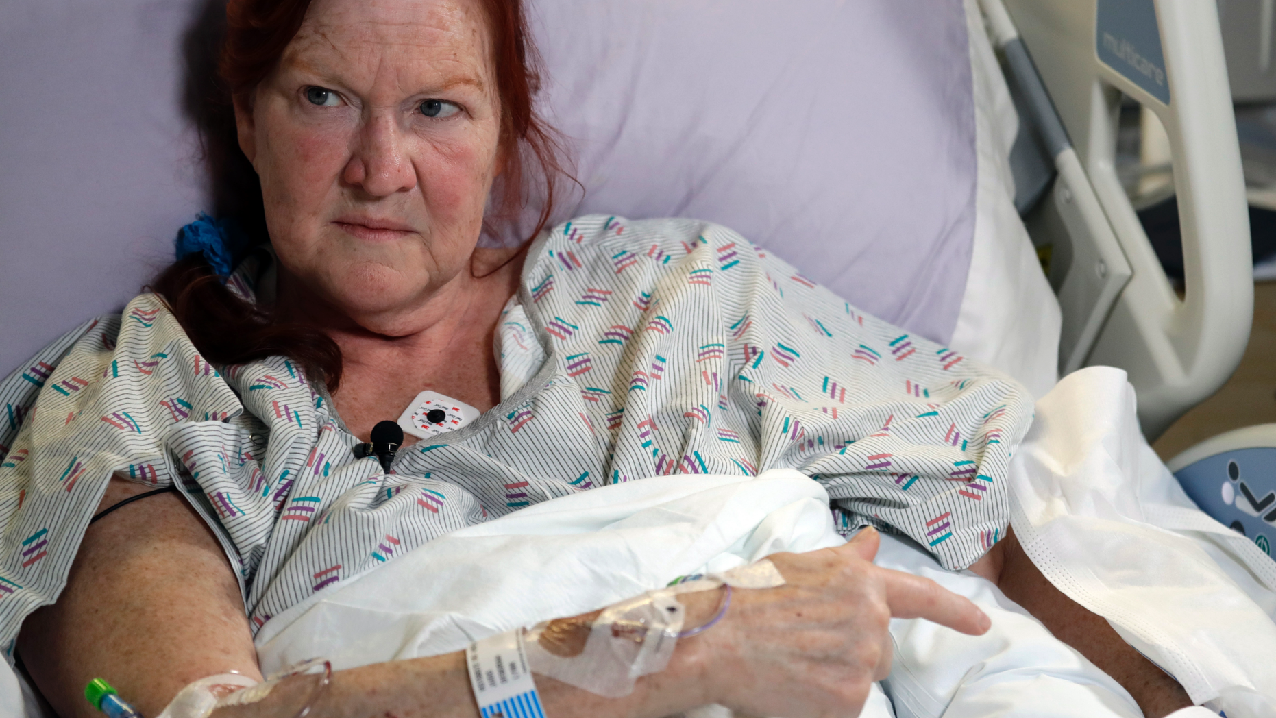 Deborah Judd, 56, sits in her hospital bed at Harborview Medical Center and talks about the injuries she suffered in a shooting a day earlier, Thursday, March 28, 2019, in Seattle. The afternoon shooting spree and carjacking in Seattle left two people dead and two injured. (AP Photo/Elaine Thompson)