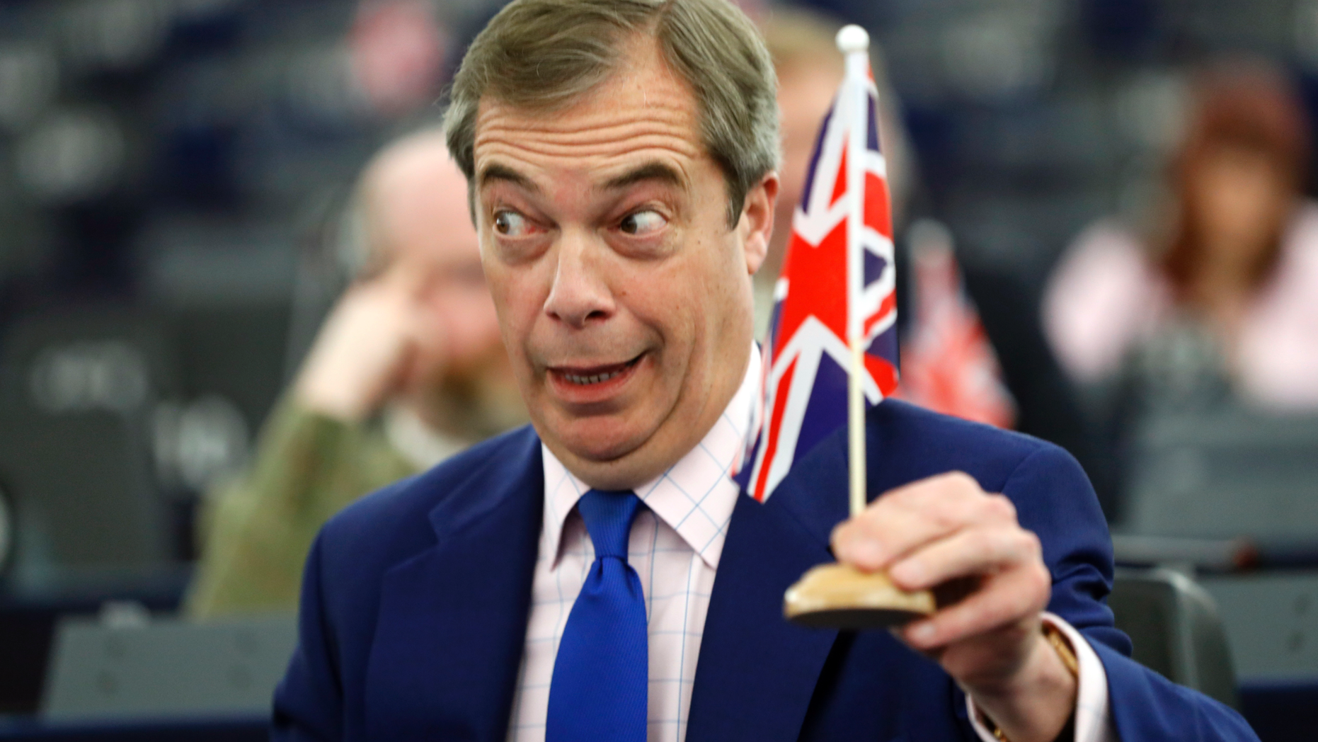 Former U.K. Independence Party (UKIP) leader and member of the European Parliament Nigel Farage holds a U.K. flag during a plenary session at the European Parliament in Strasbourg, eastern France, Wednesday, March 13, 2019. British lawmakers rejected May's Brexit deal in a 391-242 vote on Tuesday night. Parliament will vote Wednesday on whether to leave the EU without a deal. (AP Photo/Jean Francois Badias)
