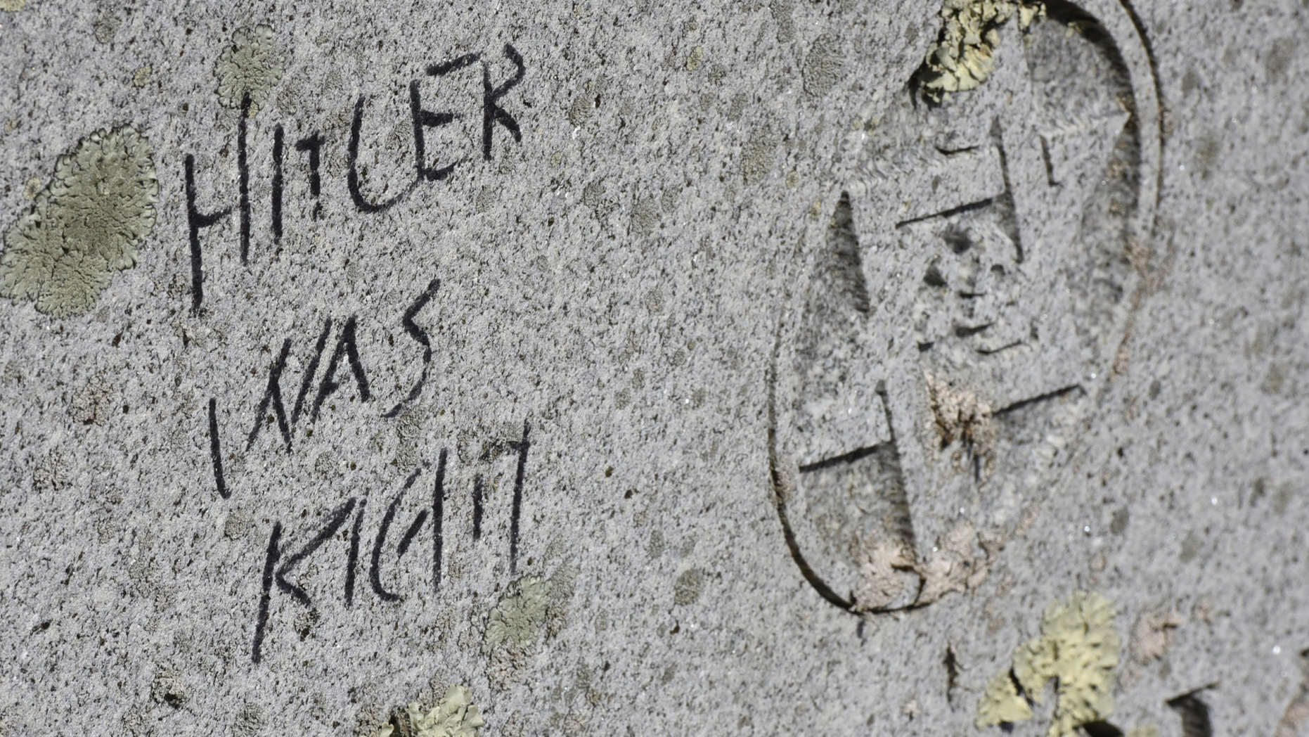 Anti-Semitic graffiti mars a memorial stone at Hebrew Cemetery in Fall River, Mass., Monday, March 18, 2019. Police now say 59 gravestones at a Jewish cemetery in Massachusetts were defaced with anti-Semitic graffiti, about twice as many as initially thought. (Jack Foley/The Herald News of Fall River via AP)