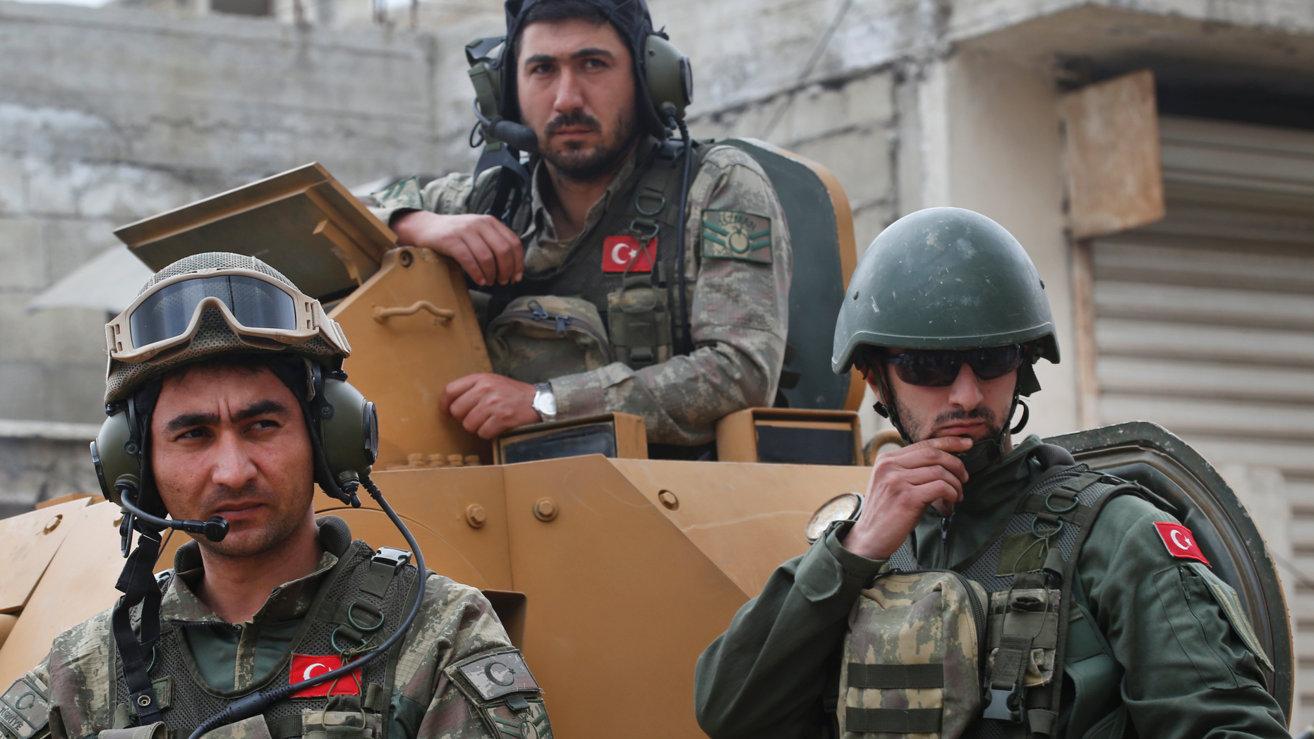 FILE - In this March 24, 2018 file photo, Turkish soldiers atop an armored personnel carrier secure the streets of the northwestern city of Afrin, Syria, during a Turkish government-organized media tour into northern Syria. Turkish military said Sunday, March. 31, 2019 that one of its soldier has been killed in Syria’s north in what Syrian activists describe as an attack by local Kurdish fighters. Turkey's ministry of defense said a mortar attack Sunday on its troops around Afrin in northwestern Syria killed one soldier and wounded another. (AP Photo/Lefteris Pitarakis, File)