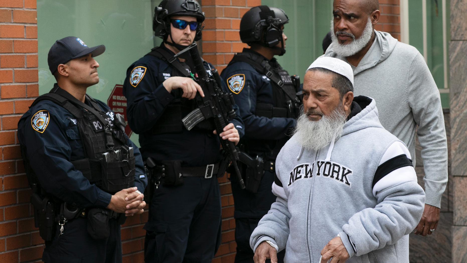 Men leave the Islamic Cultural Center of New York under increased police security following the shooting in New Zealand, Friday, March 15, 2019, in New York. (AP Photo/Mark Lennihan)