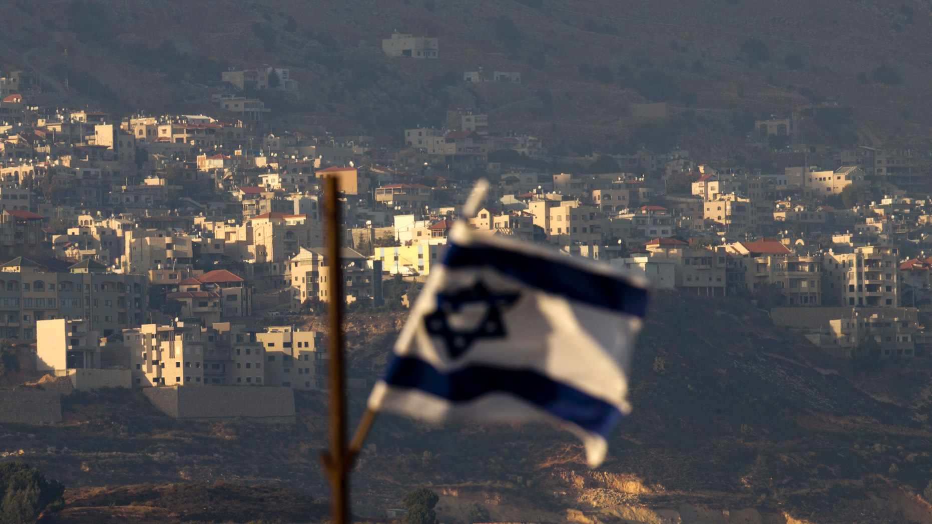 FILE - In this file photo dated Thursday, Oct. 11, 2018, an Israeli flag in front of the village of Majdal Shams in the Israeli-controlled Golan Heights. Syria slammed President Donald Trump's abrupt declaration that Washington will recognise Israel's sovereignty over the Israeli-occupied Golan Heights, saying Friday March 22, 2019, the statement was "irresponsible" and a threat to international peace and stability. (AP Photo/Ariel Schalit, FILE)