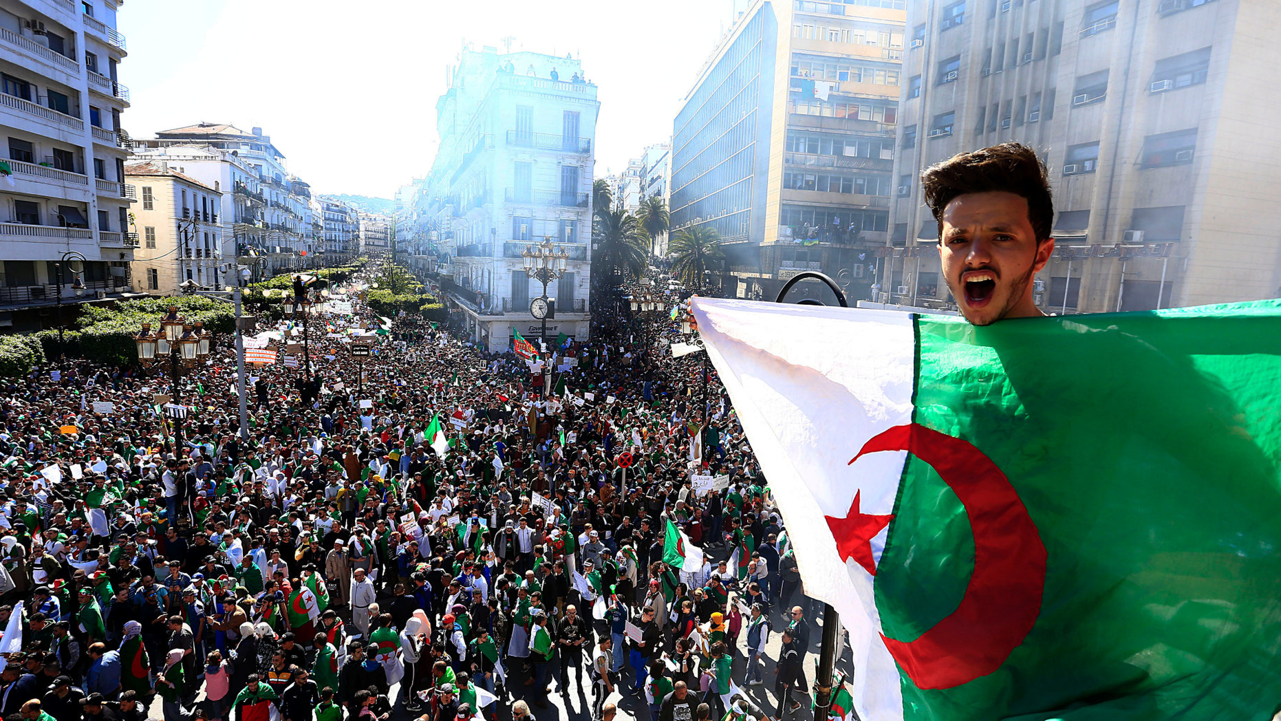 Algerian shouts as he holds the national flag during a protest in Algiers, Algeria, Friday, March 15. Tens of thousands of people gathered Friday in Algeria's capital and other cities amid heavy security for what could be decisive protests against longtime leader Abdelaziz Bouteflika. (AP Photo/Toufik Doudou)