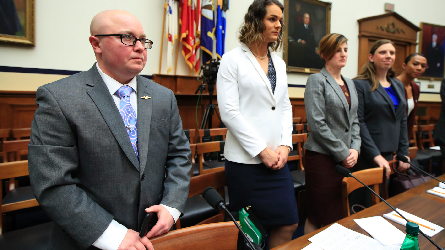 FILE - In this Feb. 27, 2019, file photo, from left, transgender military members Navy Lt. Cmdr. Blake Dremann, Army Capt. Alivia Stehlik, Army Capt. Jennifer Peace, Army Staff Sgt. Patricia King and Navy Petty Officer Third Class Akira Wyatt, listen before the start of a House Armed Services Subcommittee on Military Personnel hearing on Capitol Hill in Washington. The Defense Department has approved a new policy that will largely bar transgender troops and military recruits from transitioning to another sex, and require most individuals to serve in their birth gender. (AP Photo/Manuel Balce Ceneta, File)