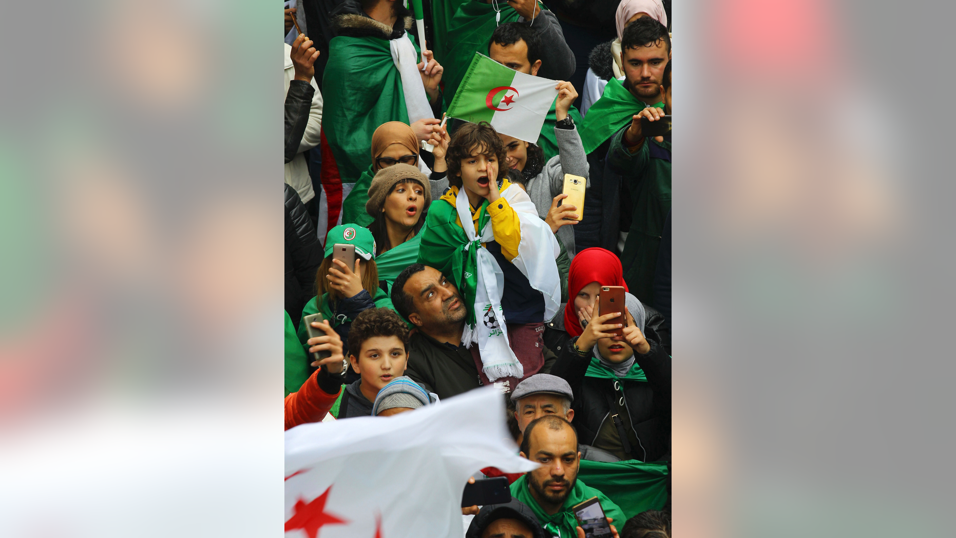 A kid wrapped in a national flag shouts during a protest in Algiers, Algeria, Friday, March 22, 2019. Thousands of Algerians are demonstrating in the major cities of the oil-rich North African country, demanding the resignation of ailing, 82-year-old President Abdelaziz Bouteflika. (AP Photo/Fateh Guidoum)
