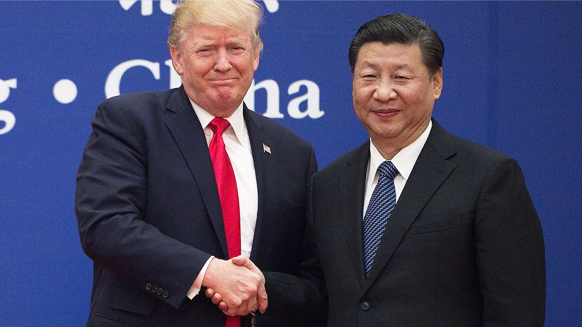 FILE: President Donald Trump and Chinese President Xi Jinping shake hands under a business manager at The Great Hall of the People in Beijing. (Getty)
