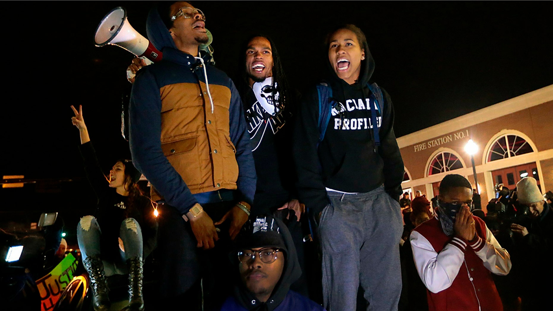 Ferguson activist Daren Seals, top center, awaits the decision by a grand jury on whether to indict Darren Wilson in the death of Michael Brown in front of the police station in Ferguson , Mo.