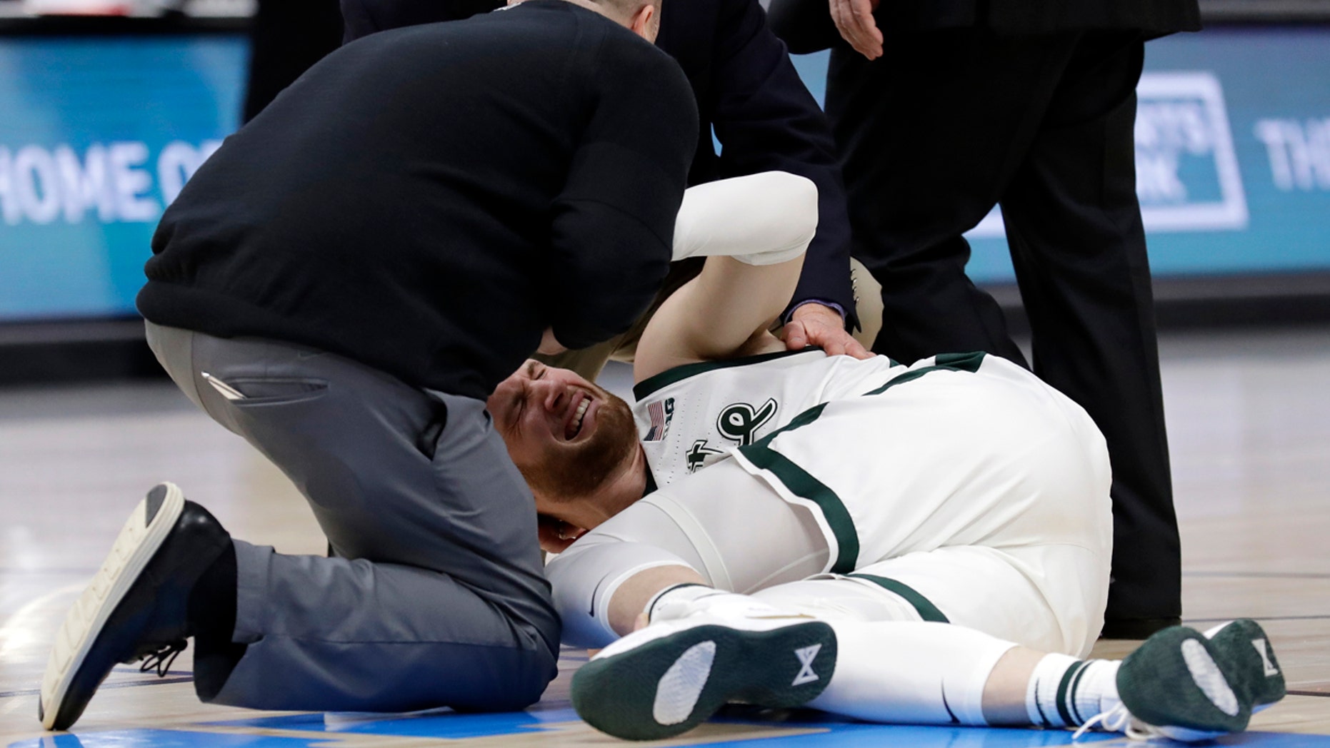 March 17: Medical personnel checks on Michigan State's Kyle Ahrens during the first half of an NCAA college basketball championship game against Michigan in the Big Ten Conference tournament.