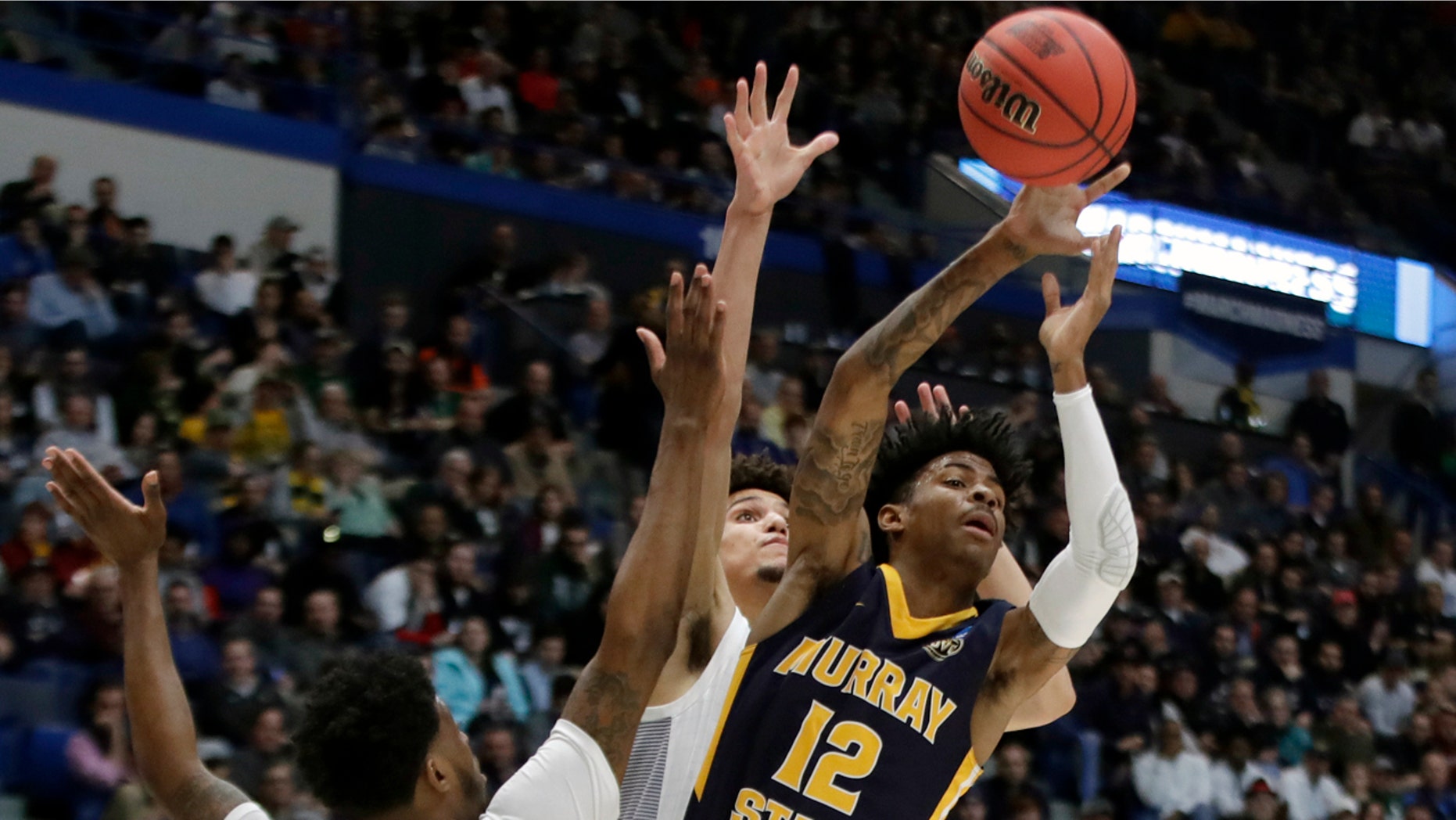 Murray State's Yes Morant (12) passes the ball under pressure from Marquette's Sacar Anim and Brendan Bailey, behind the first half of Thursday's game. (AP Photo / Elise Amendola)