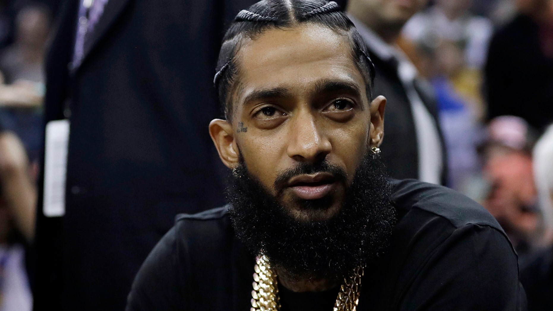 DOSSIER - In this archival photo of March 29, 2018, rapper Nipsey Hussle observes an NBA basketball match between the Golden State Warriors and the Milwaukee Bucks in Oakland, California. Grammy-nominated and highly respected rapper Nipsey Hussle was killed and shot dead Los Angeles Mayor Eric Garcetti said Sunday, March 31, 2019 that he was 33 years old, in front of his clothing store in Toronto. Los Angeles. (AP Photo / Marcio Jose Sanchez, File)