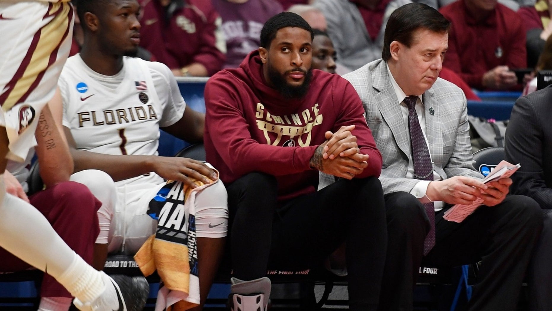 Florida State University player Phil Cofer (center seated with a shoe on the foot) learned after his team's victory at the Vermont NCAA tournament that his father, linebacker Mike Cofer of the Detroit Lions, was dead. 