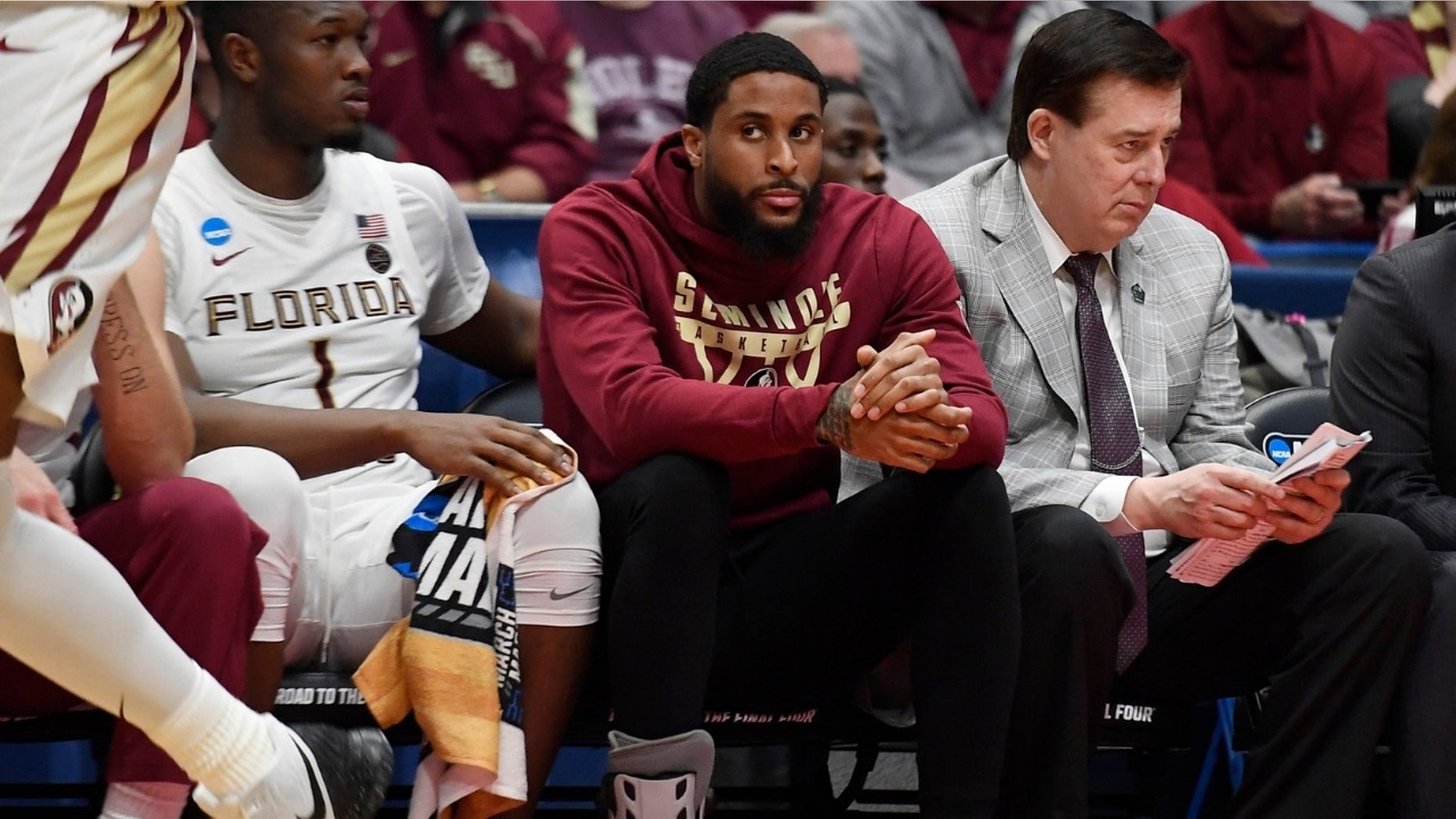 Florida State University player Phil Cofer (center seated with a shoe on the foot) learned after his team's victory at the Vermont NCAA tournament that his father, linebacker Mike Cofer of the Detroit Lions, was dead. 