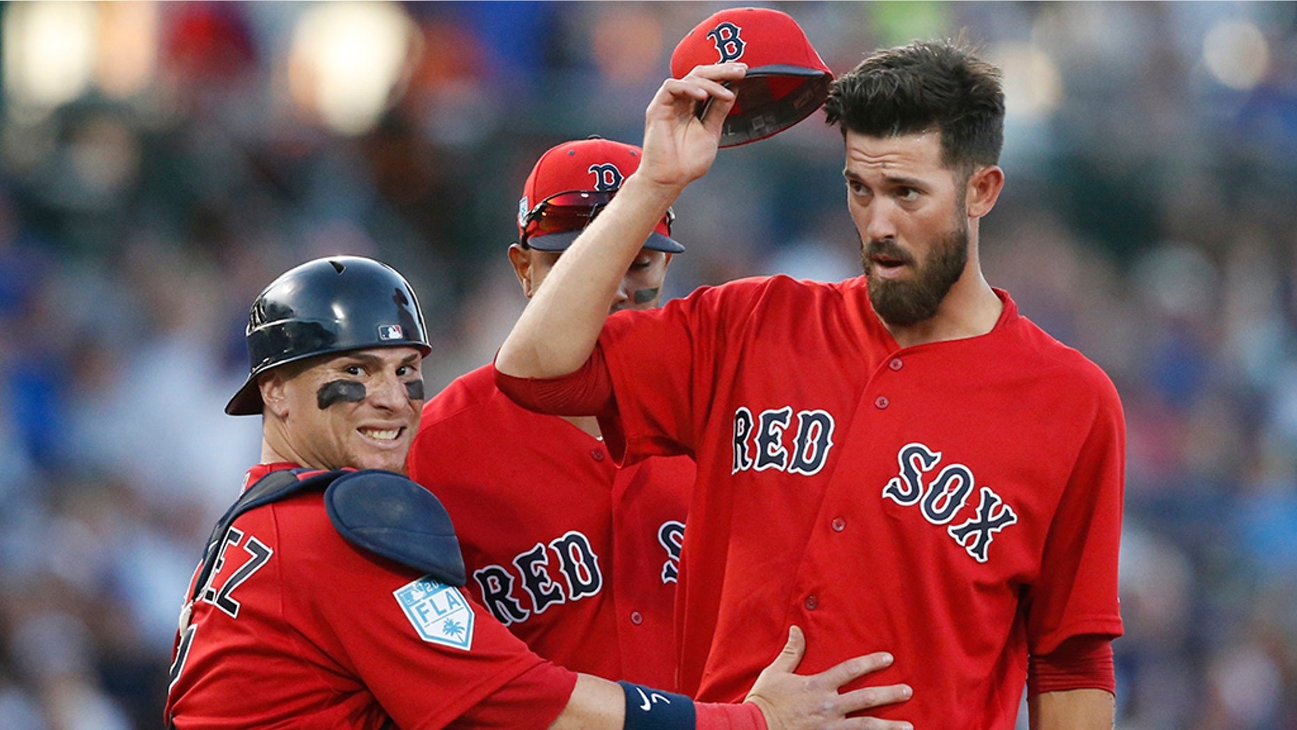 Boston Red Sox catcher Christian Vazquez, left, calls for someone to come and check out starting pitcher Rick Porcello, right, after Porcello was knocked over by a batted ball during the second inning of a spring training baseball game against the Chicago Cubs on Monday in Mesa, Ariz.