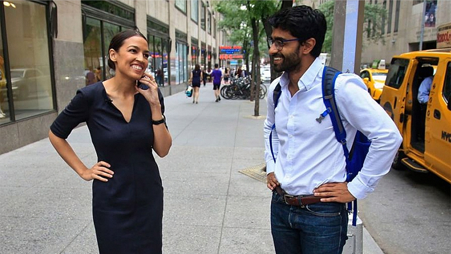 Alexandria Ocasio-Cortez, left, the winner of the Democratic primary in New York's 14th Congressional District, speaks on a phone as Saikat Chakrabarti, her senior campaign adviser stands by, Wednesday, June 27, 2018, in New York.