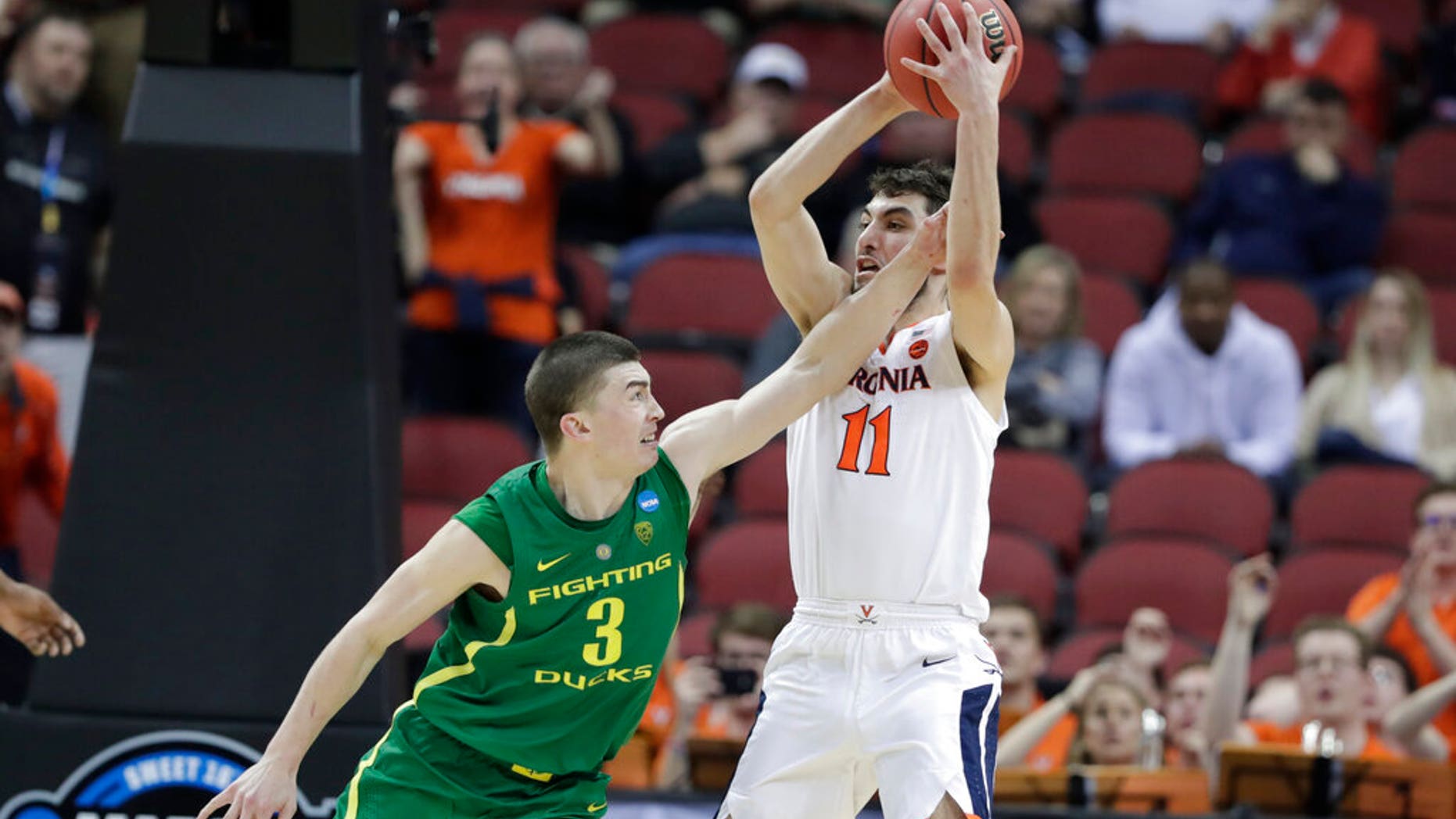 Virginia's Ty Jerome (11) is fouled by Oregon's Payton Pritchard (3) during the second half of a men's NCAA Tournament college basketball South Regional semifinal game. (Associated Press)