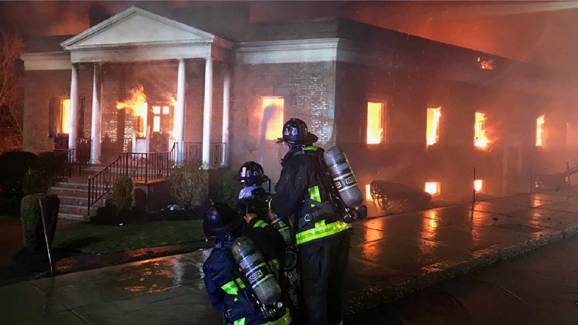Firefighters battle a 9-alarm fire at New England Casket Company on Friday.