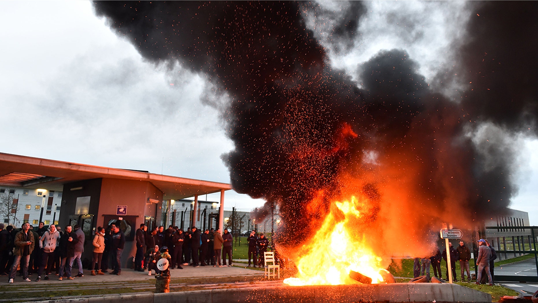 The entrances to 18 prisons in France were blocked by guards who burned tires and other materials at the gates in protest of the stabbing of two colleagues at a jail in northwest France which is being described as a "terrorist" attack