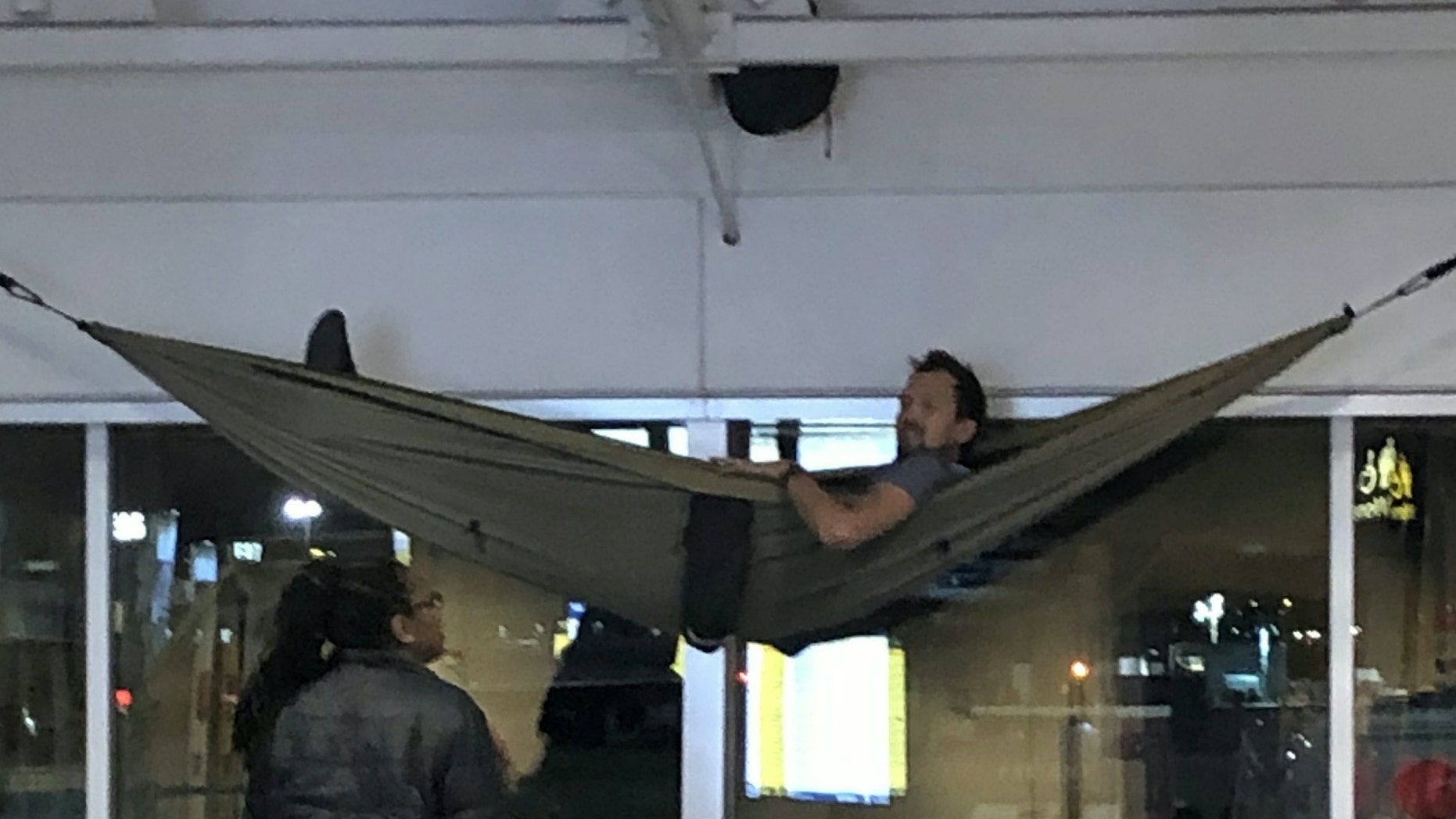 The traveler was spotted snoozing in his "genius" setup on Sunday morning.