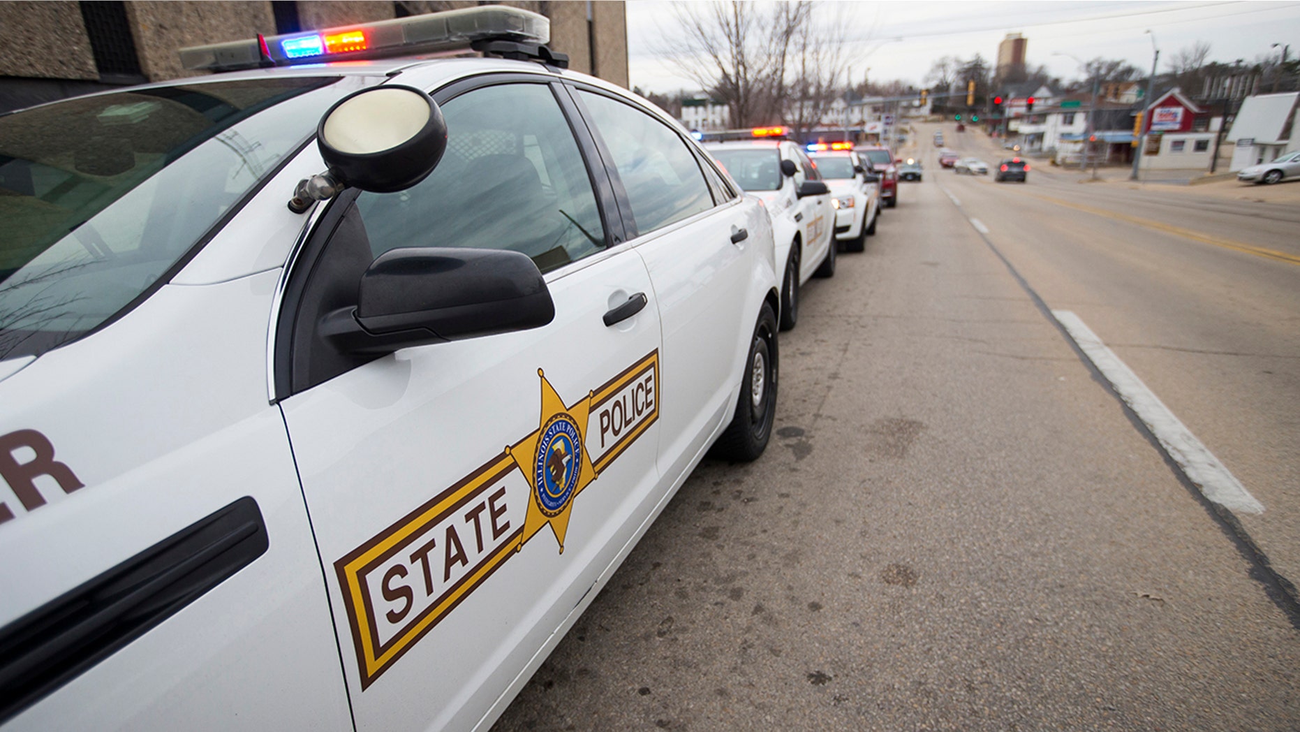Illinois State Police vehicles line up outside the Stephenson County Coroner's office on Thursday in Freeport after a procession to deliver the body of Trooper Brooke Jones-Story, who was struck and killed by a truck while conducting a traffic stop earlier in the day. (Scott P. Yates/Rockford Register Star via AP)