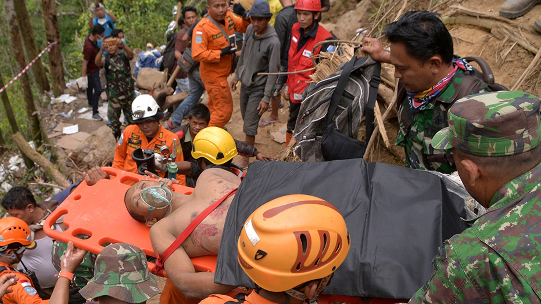 Rescuers carry a survivor of a collapsed mine on a stretcher in Bolaang Mongondow, North Sulawesi, Indonesia, on Thursday.