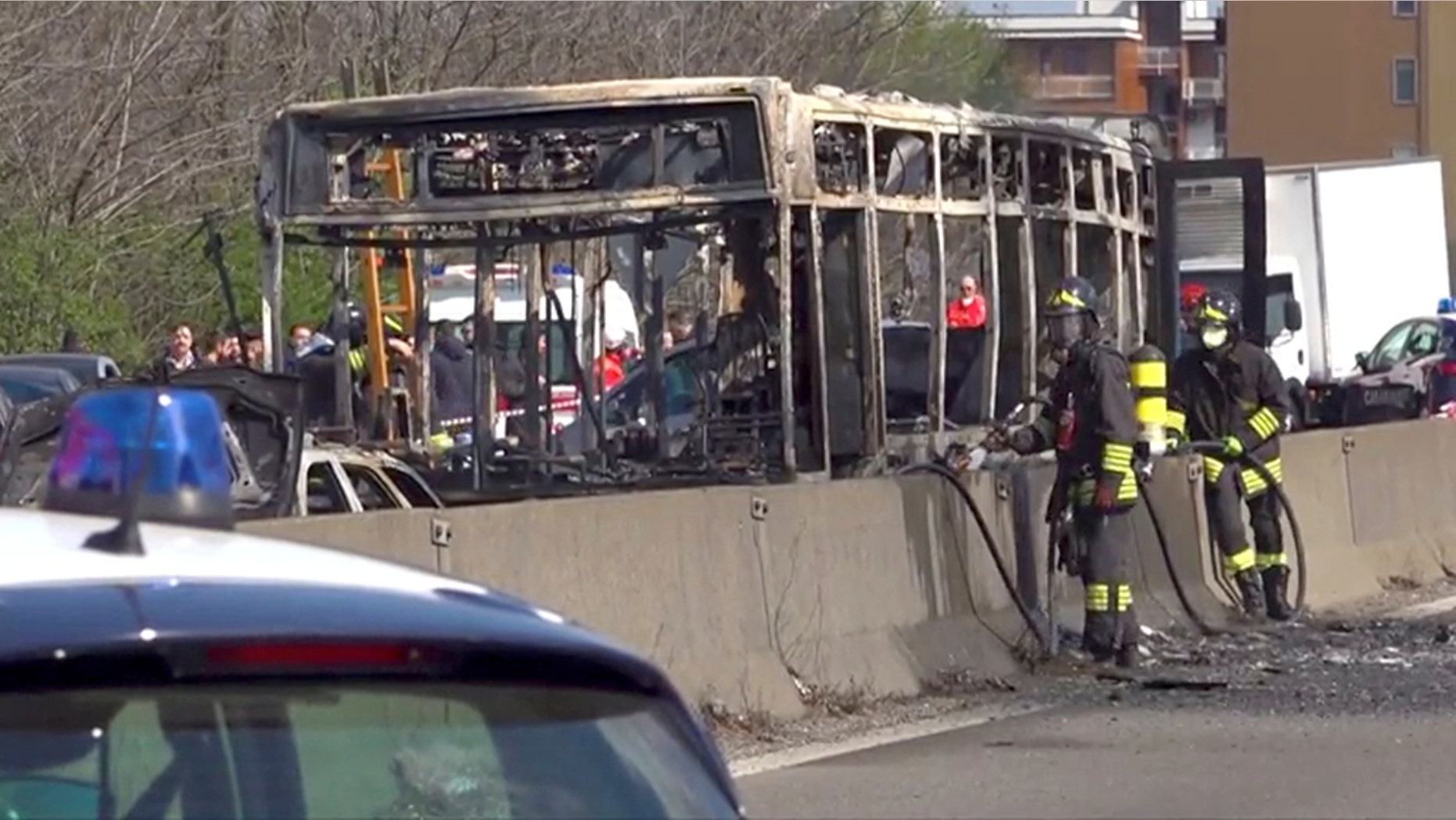 The wreckage of a bus that was set ablaze by its driver in protest against the treatment of migrants trying to cross the Mediterranean Sea, is seen on a road in Milan, Italy.